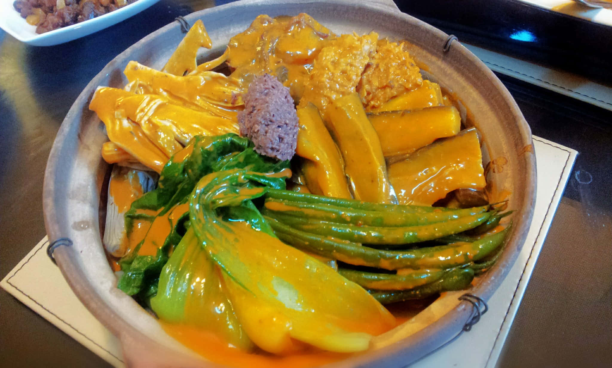 鍋中美味咖喱牛尾湯 壁紙 — 一個冒煙的陶鍋，盛滿鮮黃色的咖喱、嫩綠的蔬菜和金黃色的豆腐，配上濃郁的醬汁。