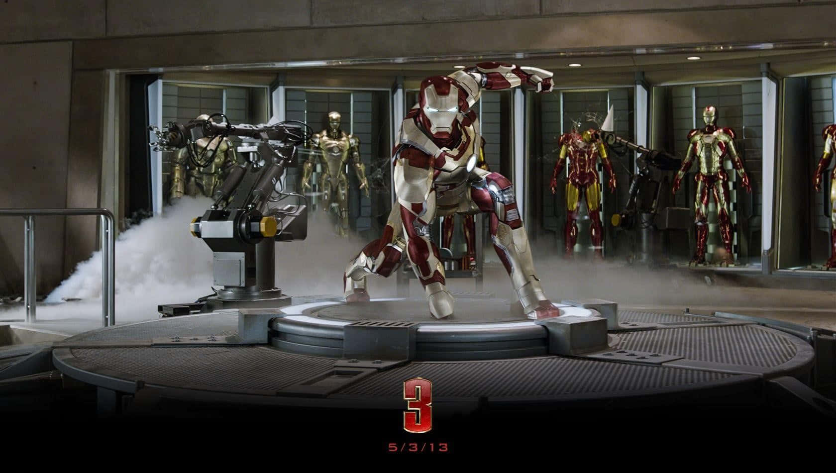 Iron Man Suit 桌布 壁紙 — 鐵甲奇俠套裝啟動，煙霧從一個圓形平台升起，實驗室內充滿其他套裝。