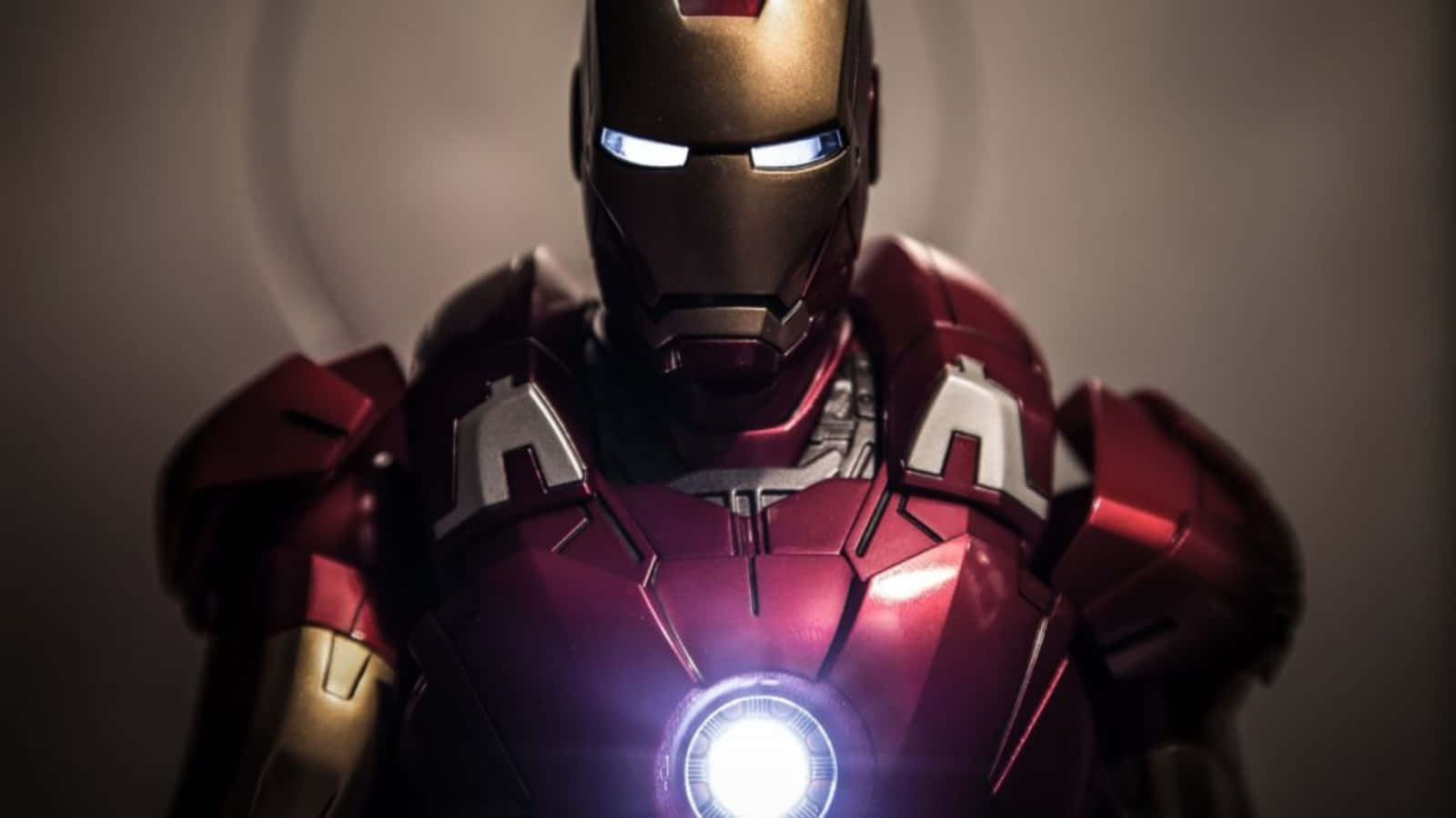 Vibranium Suit 桌布 壁紙 — 鐵甲奇俠發光紅色和金色盔甲的近距離特寫，帶有明亮的藍色眼睛和胸部弧形反應器。