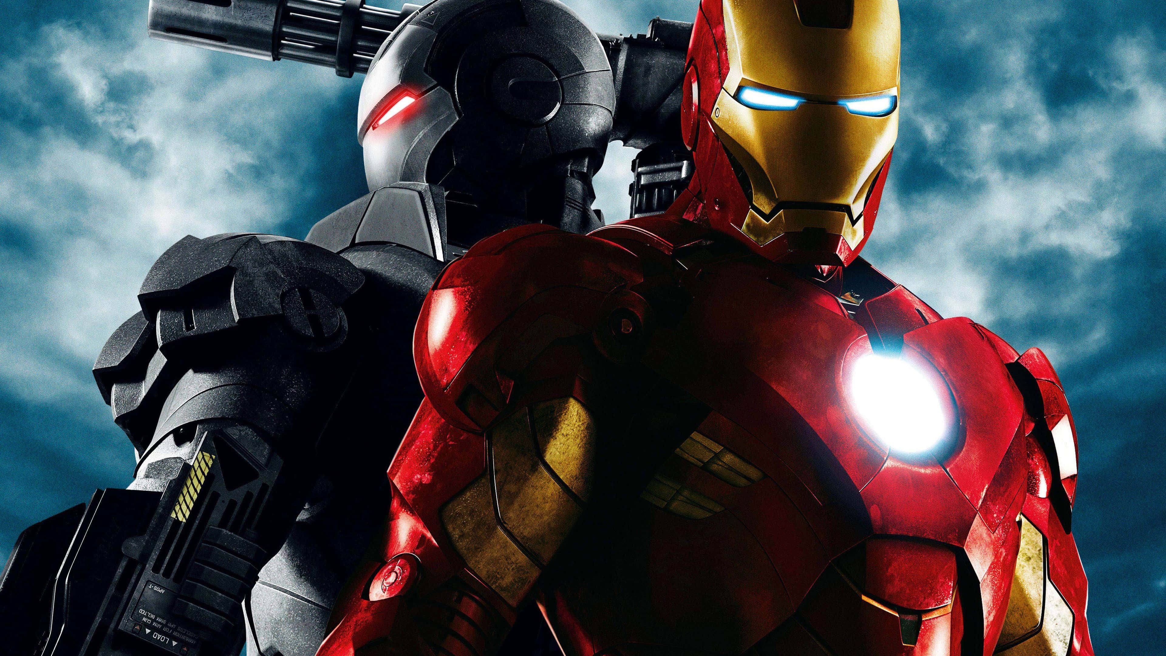 Iron Man Movies 桌布 壁紙 — 鐵甲奇俠與戰爭機器身穿細節豐富的戰甲，在暴風雨的天空下並肩而立，眼睛和胸口燈光閃爍。