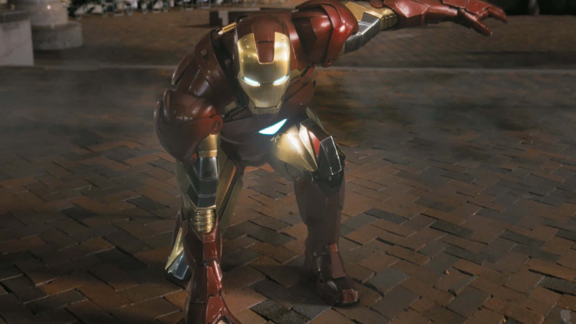 Iron Man Action Figures 桌布 壁紙 — 鐵甲奇俠身穿紅金戰甲，蹲在濕漉漉的磚砌路面上，眼睛和斥力炮發出光芒。
