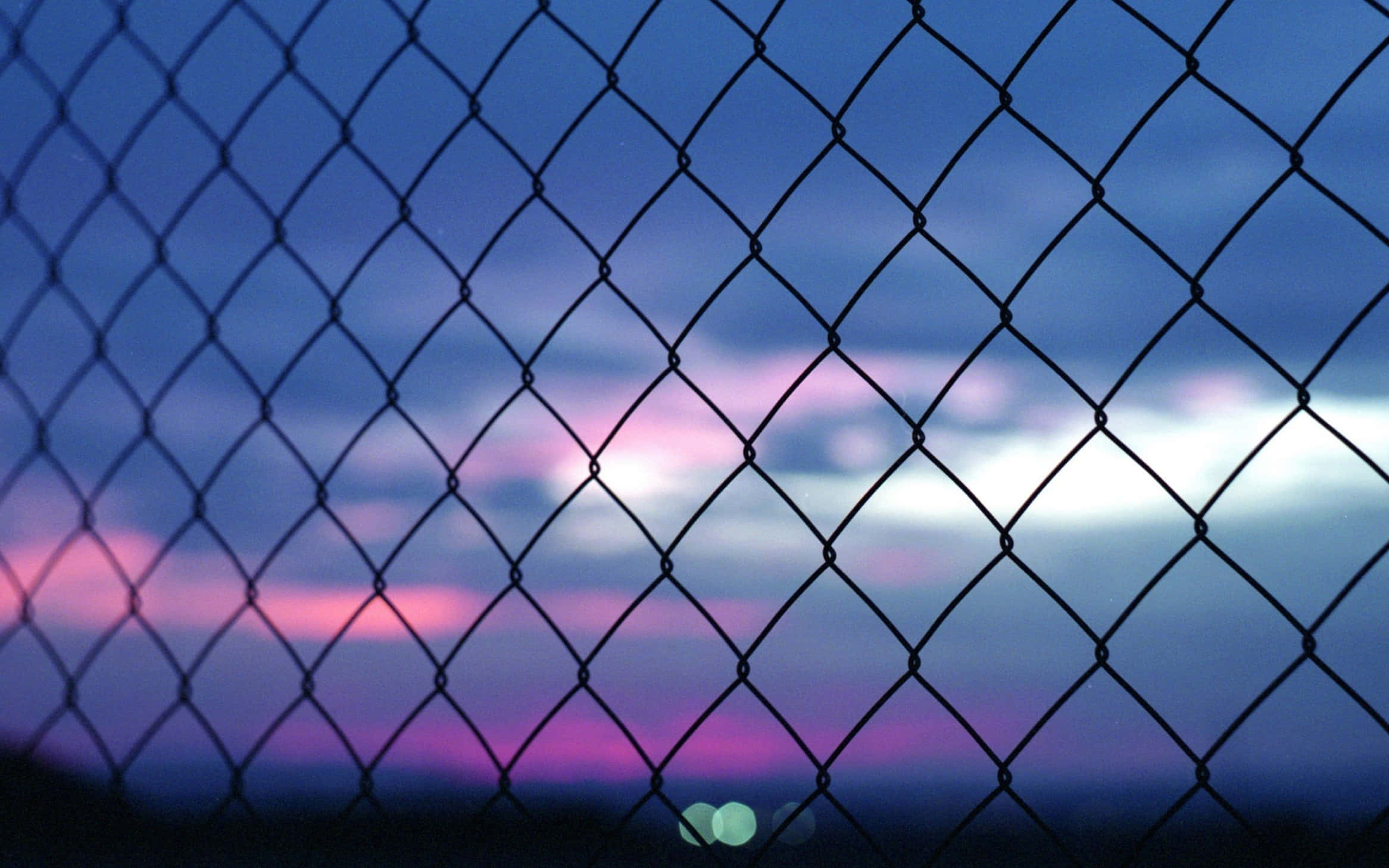 Aesthetic YouTube 桌布 壁紙 — 鐵絲網在塗上柔和紫色、粉紅色和藍色的暮色天空下呈現剪影。