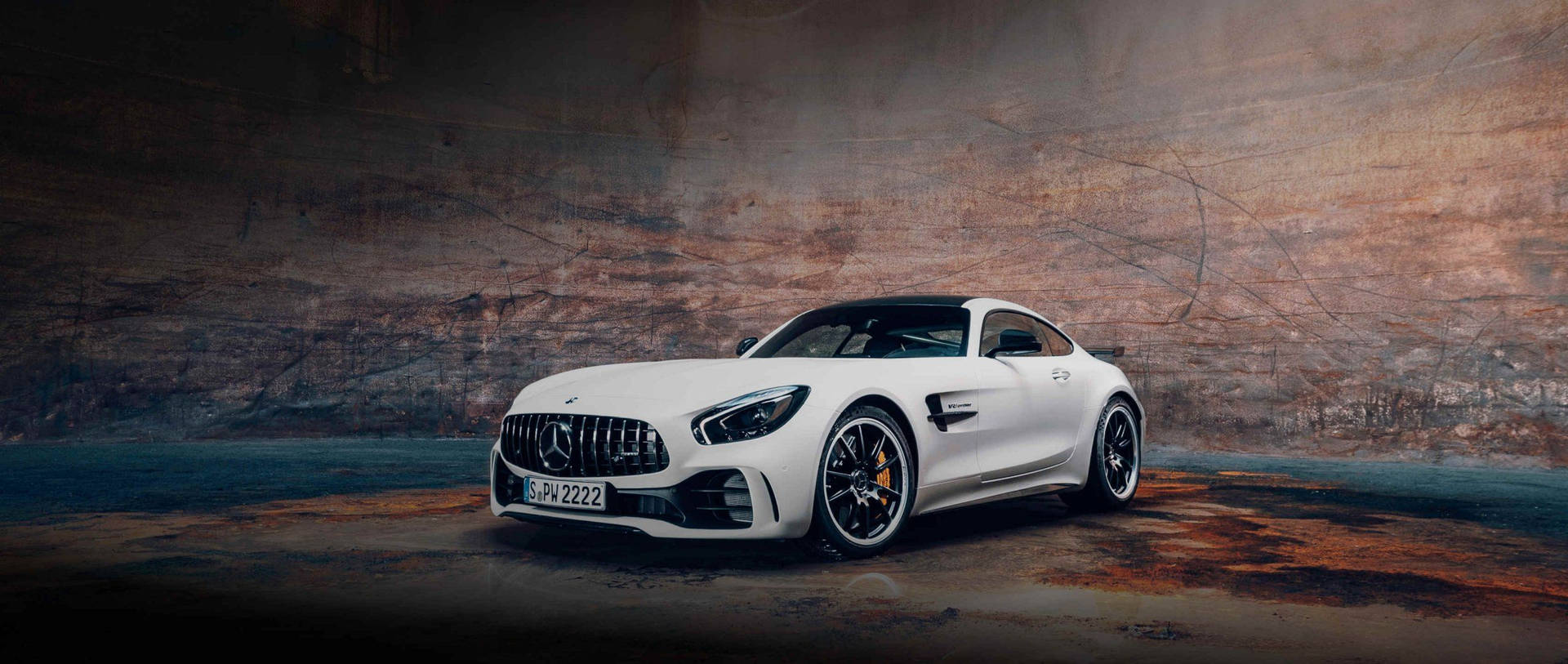 白色Mercedes-AMG GT跑車在粗獷的工業環境中。