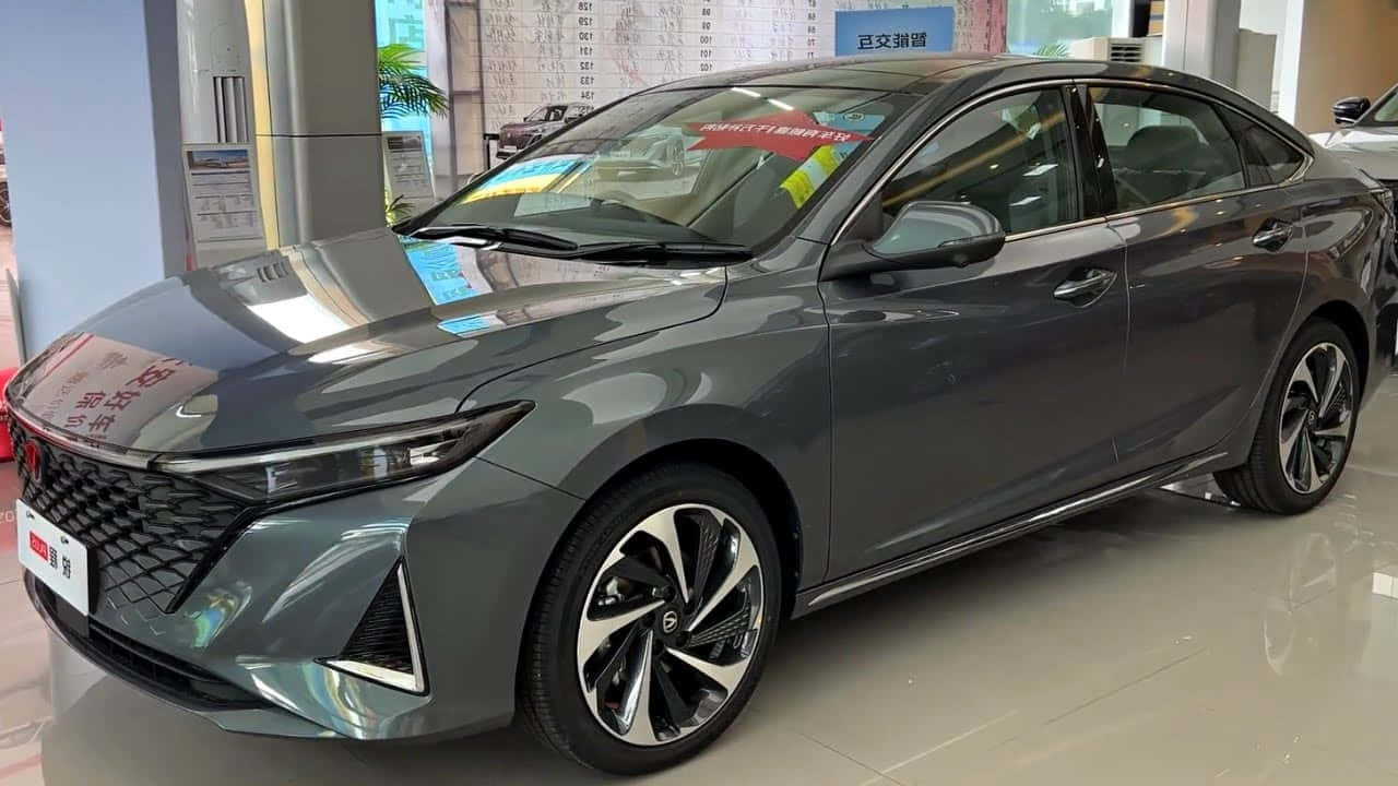 長安逸動 CC 展廳展示 壁紙 — 一輛時尚的灰色轎車配備時尚合金輪圈，在明亮的展廳燈光下於室內展示。