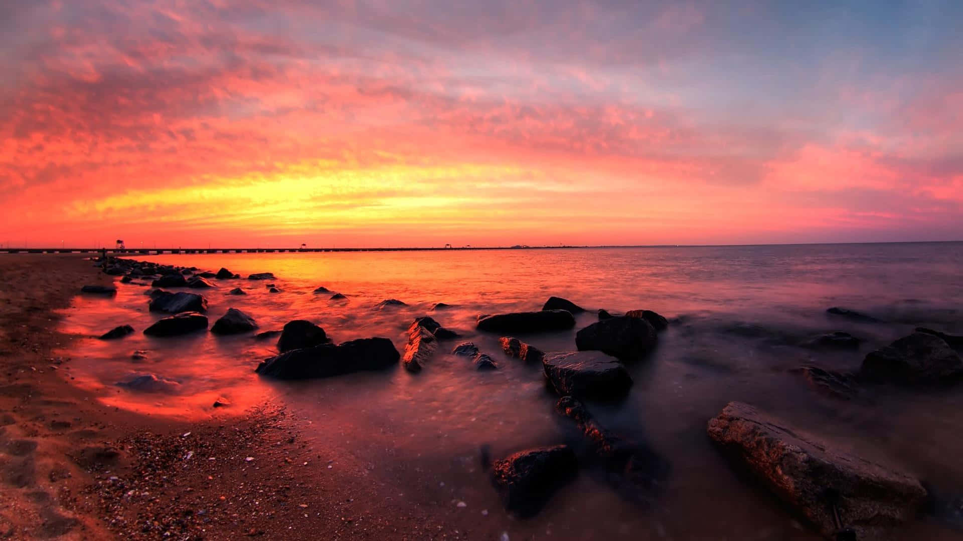 Sunset Landscape 桌布 壁紙 — 長時間曝光的日落將海洋和岩石海岸染成火熱的橙色和粉紅色調。