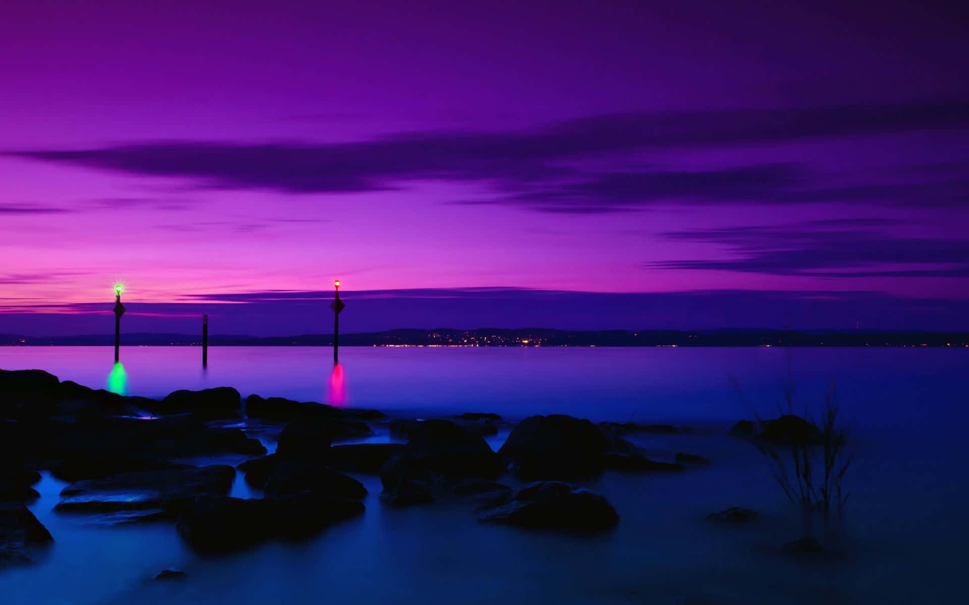 Purple Sunset 桌布 壁紙 — 長時間曝光的暮色海景，帶有發光的紫色天空和兩個明亮的浮標，在平靜的水面上投射出色彩繽紛的倒影。