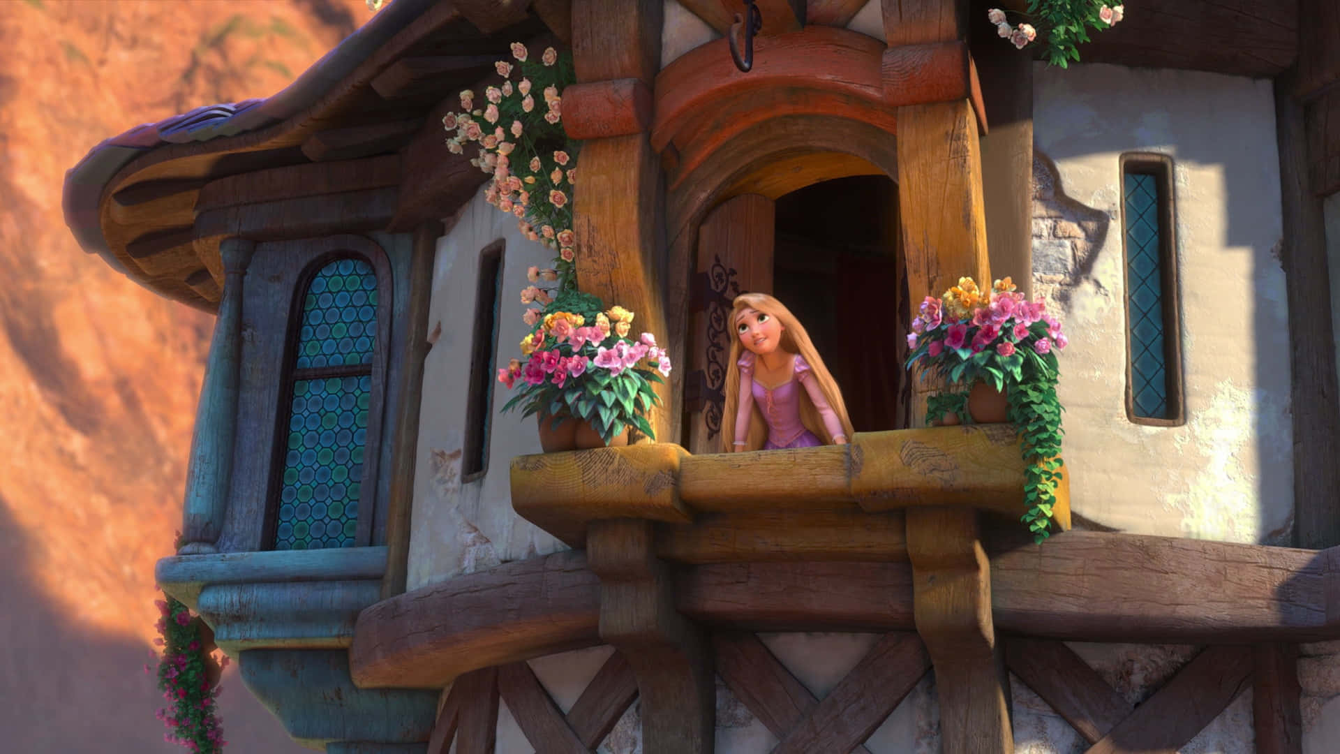 Rapunzel 桌布 壁紙 — 長髮公主靠在她的塔樓陽台上，周圍是溫暖陽光下鮮豔的花朵。