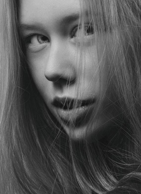 年輕女性的黑白特寫肖像，頭髮勾勒臉部輪廓。