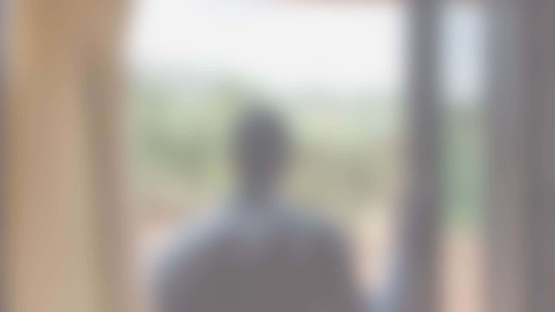 模糊人影站在門口望向外面綠色。