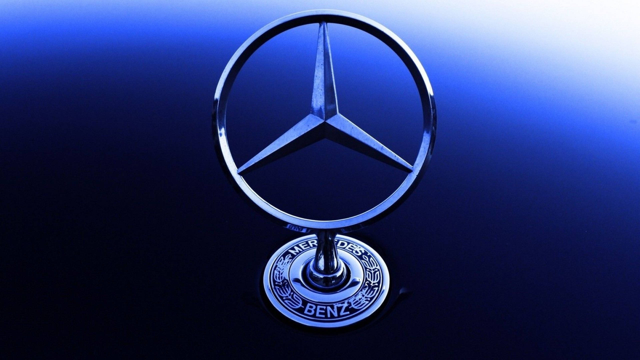 藍色 桌布 壁紙 — 閃亮的 Mercedes-Benz 標誌在冷藍光下，在漸變深藍色背景上閃耀。
