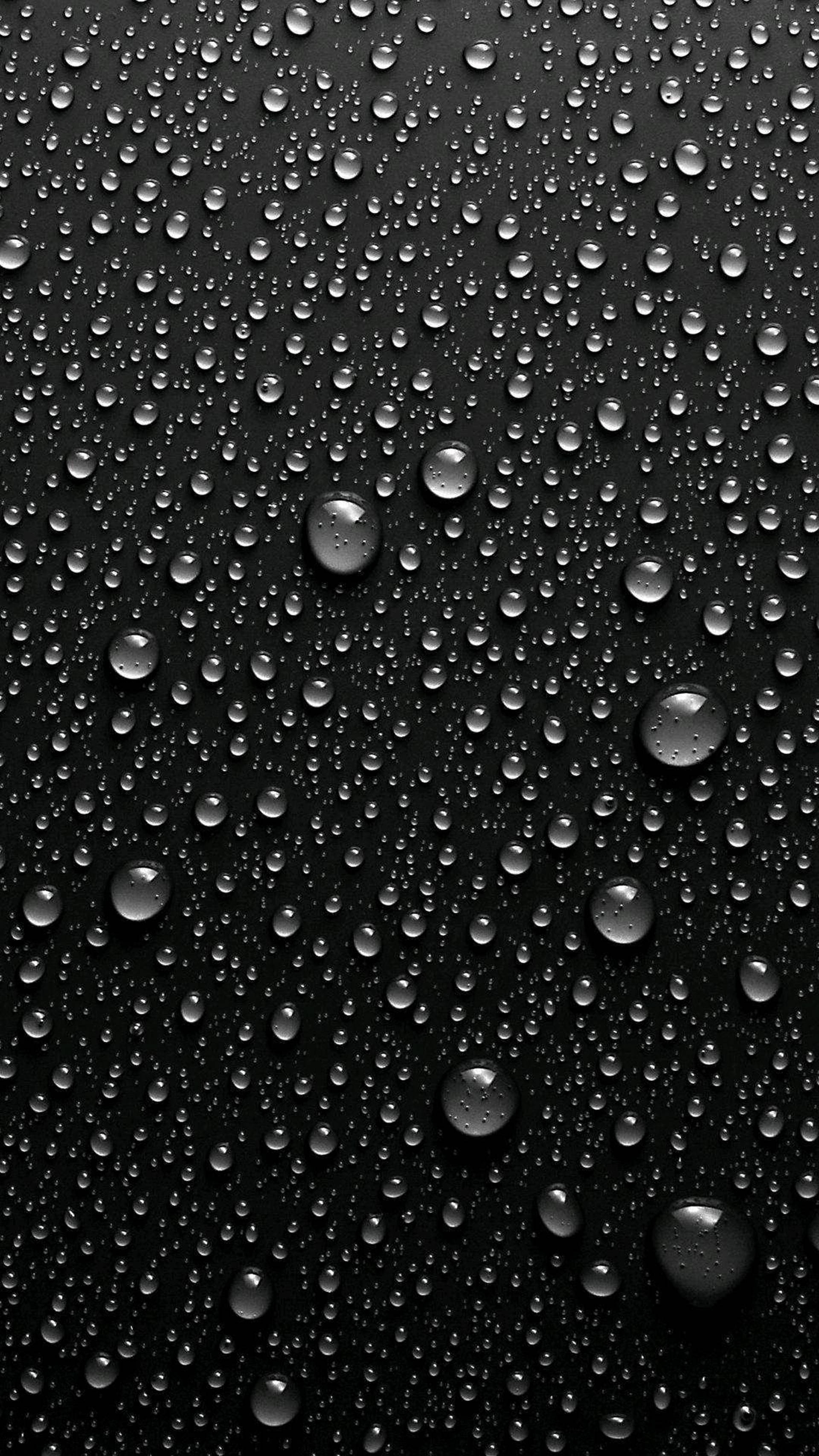 黑色 iPhone 壁紙 桌布 壁紙 — 閃亮的水滴依附在光滑的黑色表面上，營造出極簡的單色紋理。