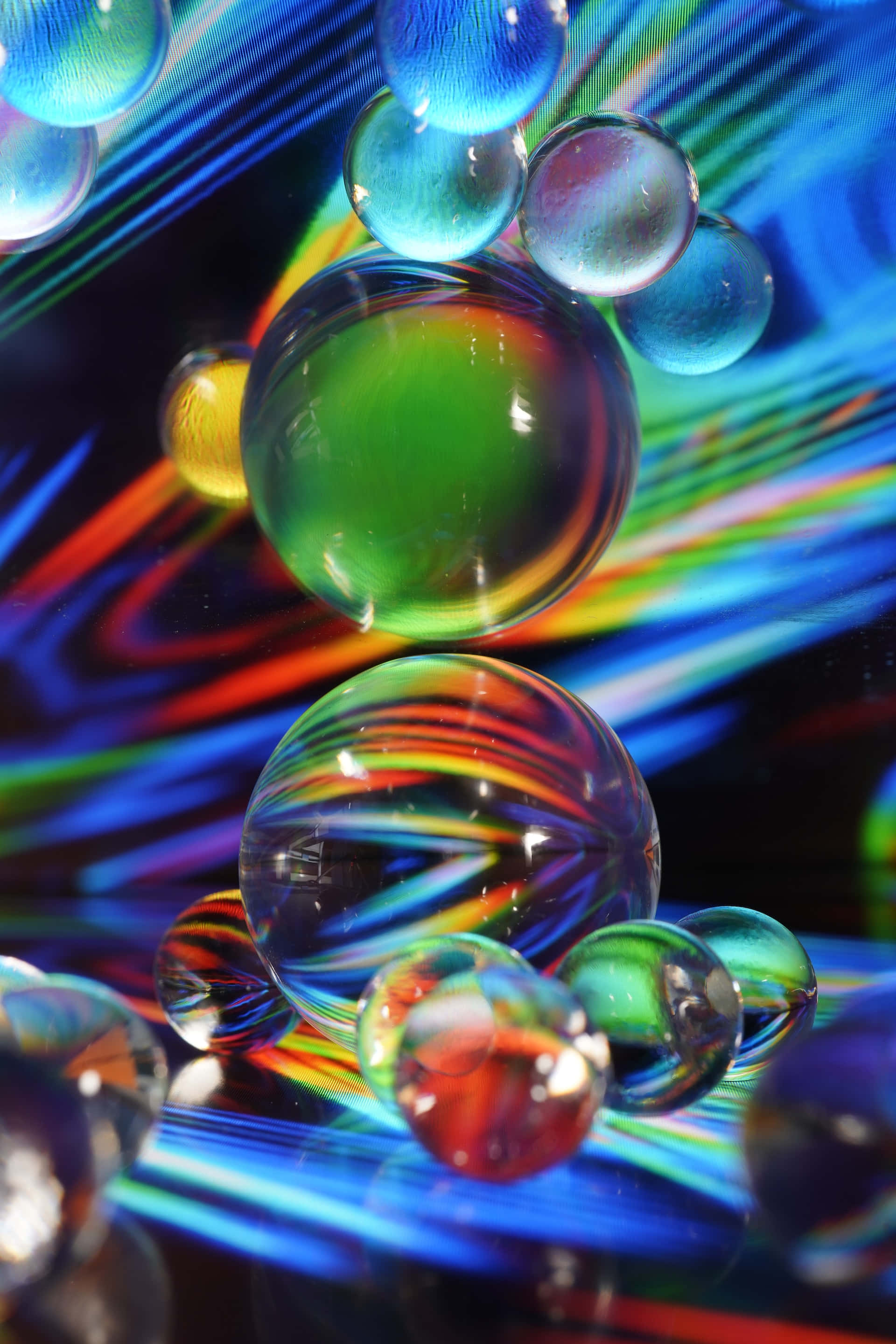 Psychedelic Neon Lights 桌布 壁紙 — 閃亮的玻璃彈珠漂浮在充滿活力的藍、紅、綠色條紋背景上。