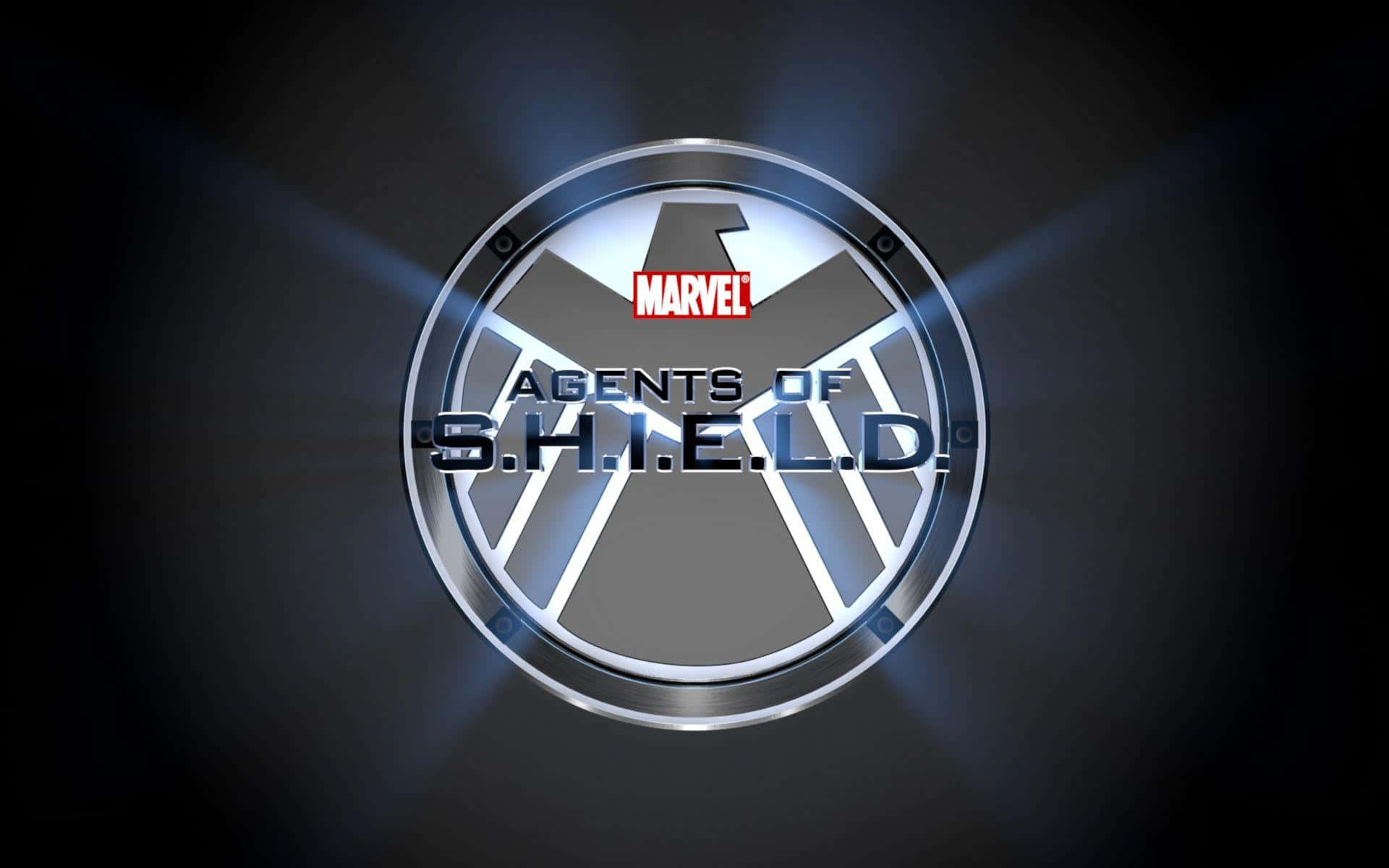 shield 桌布 壁紙 — 閃亮的金屬 S.H.I.E.L.D. 標誌，帶有從中心向四周輻射的發光藍色光線，背景為深色。