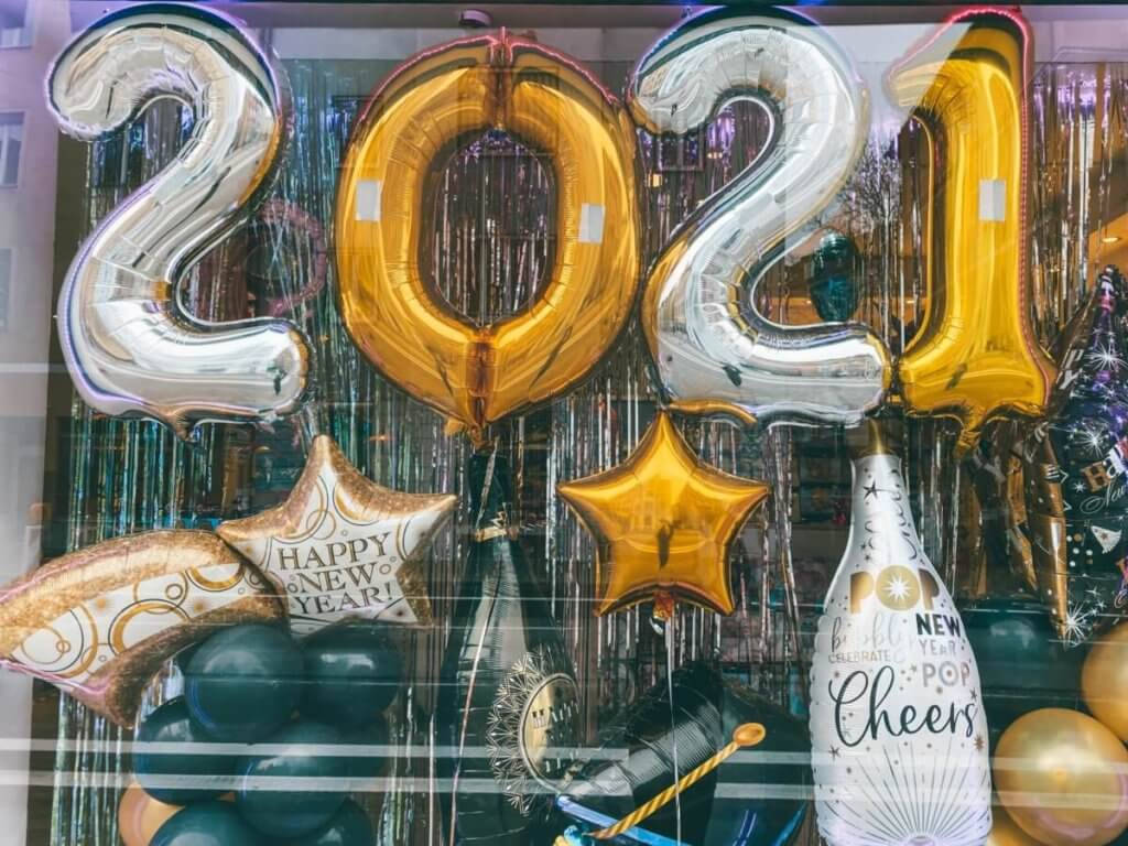 Happy New Year 2021 桌布 壁紙 — 閃亮的銀色和金色2021氣球及節日裝飾點綴著除夕慶祝活動的櫥窗展示。