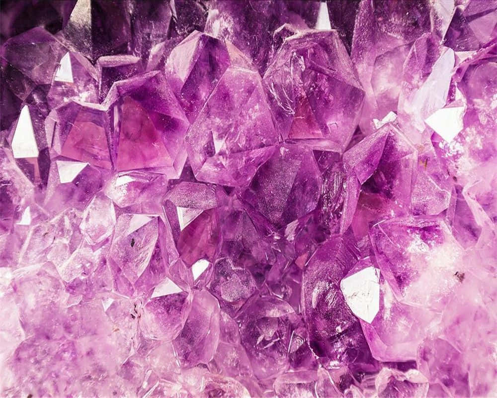 Amethyst 桌布 壁紙 — 閃亮紫色紫水晶晶體的近距離特寫，具有銳利的切面和發光的半透明感。