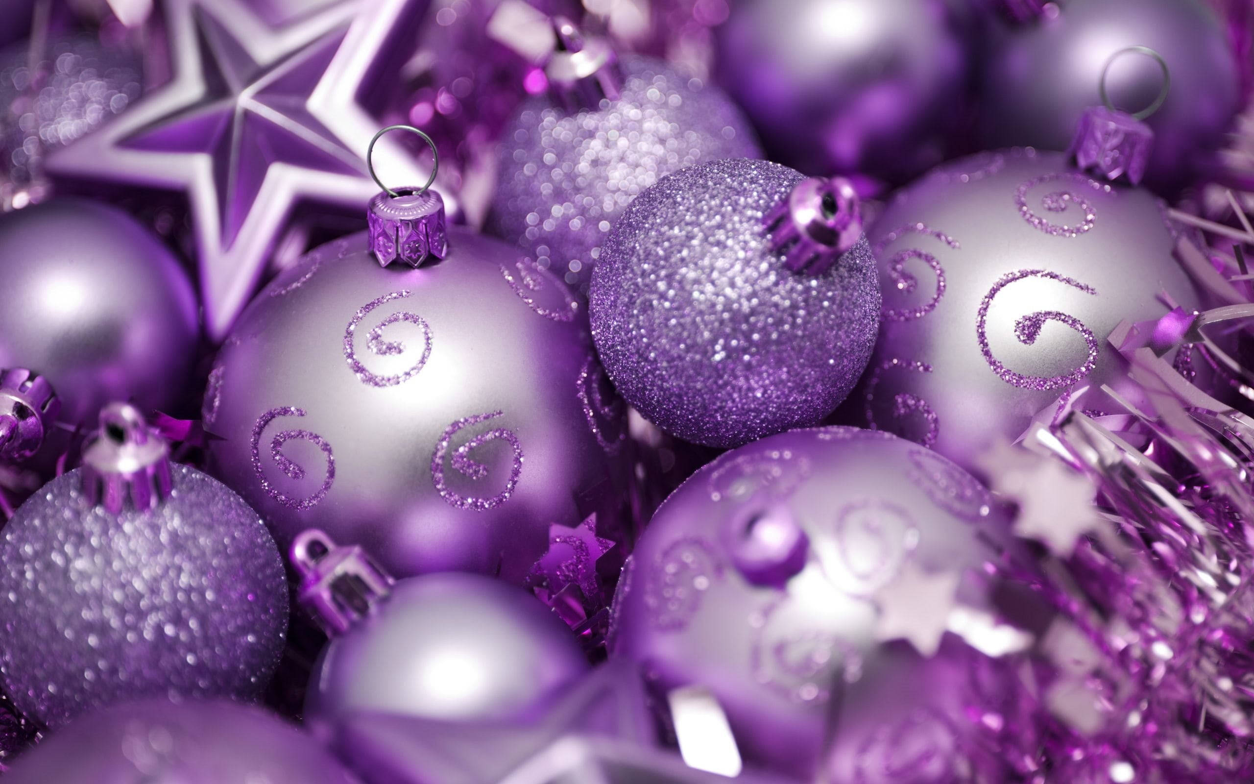 Christmas Balls 桌布 壁紙 — 閃亮紫色聖誕裝飾品和星星的特寫，帶有閃粉漩渦和金屬箔，營造出節日氣氛。