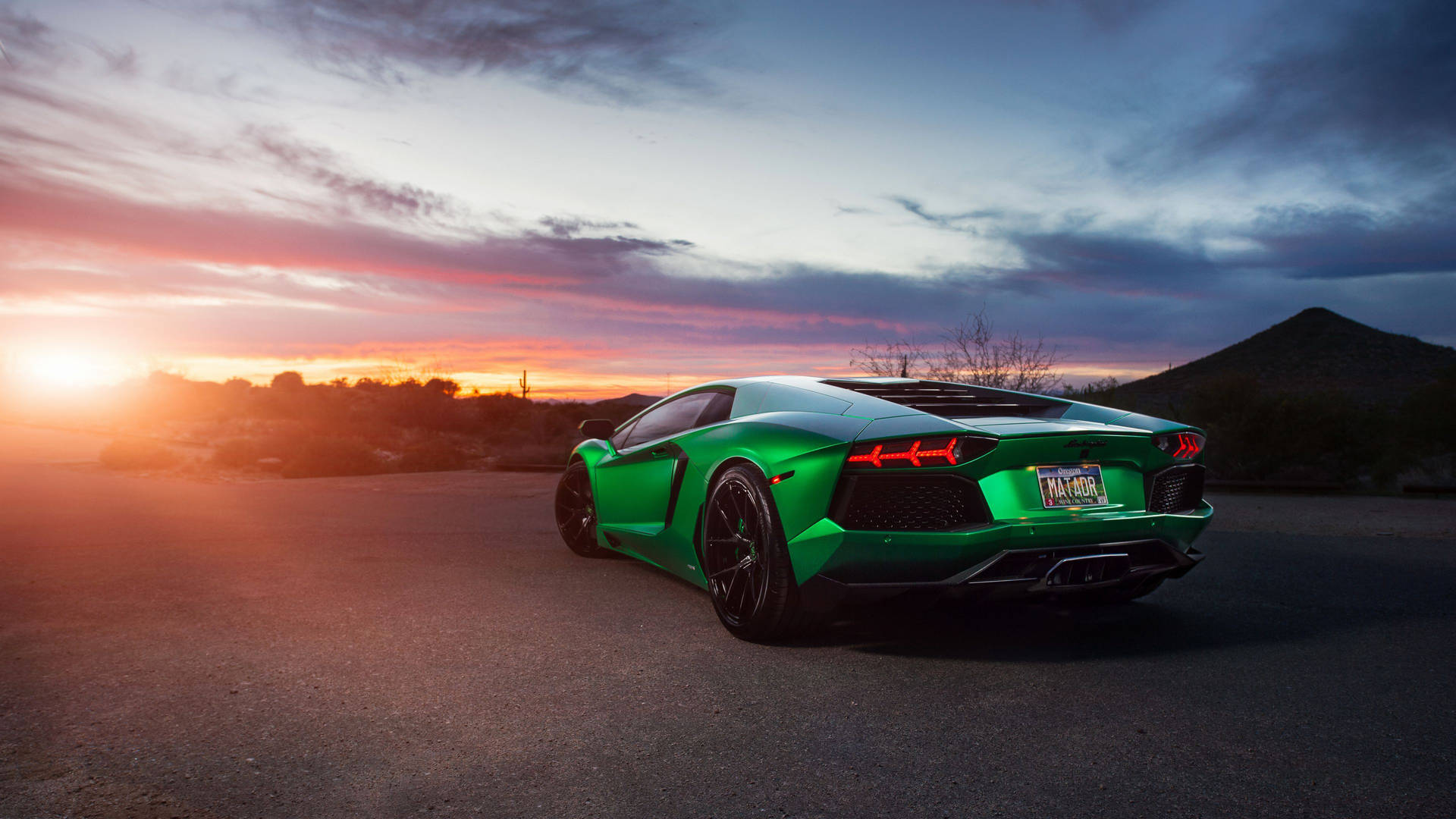 日落沙漠景觀中的綠色林寶堅尼 Aventador
