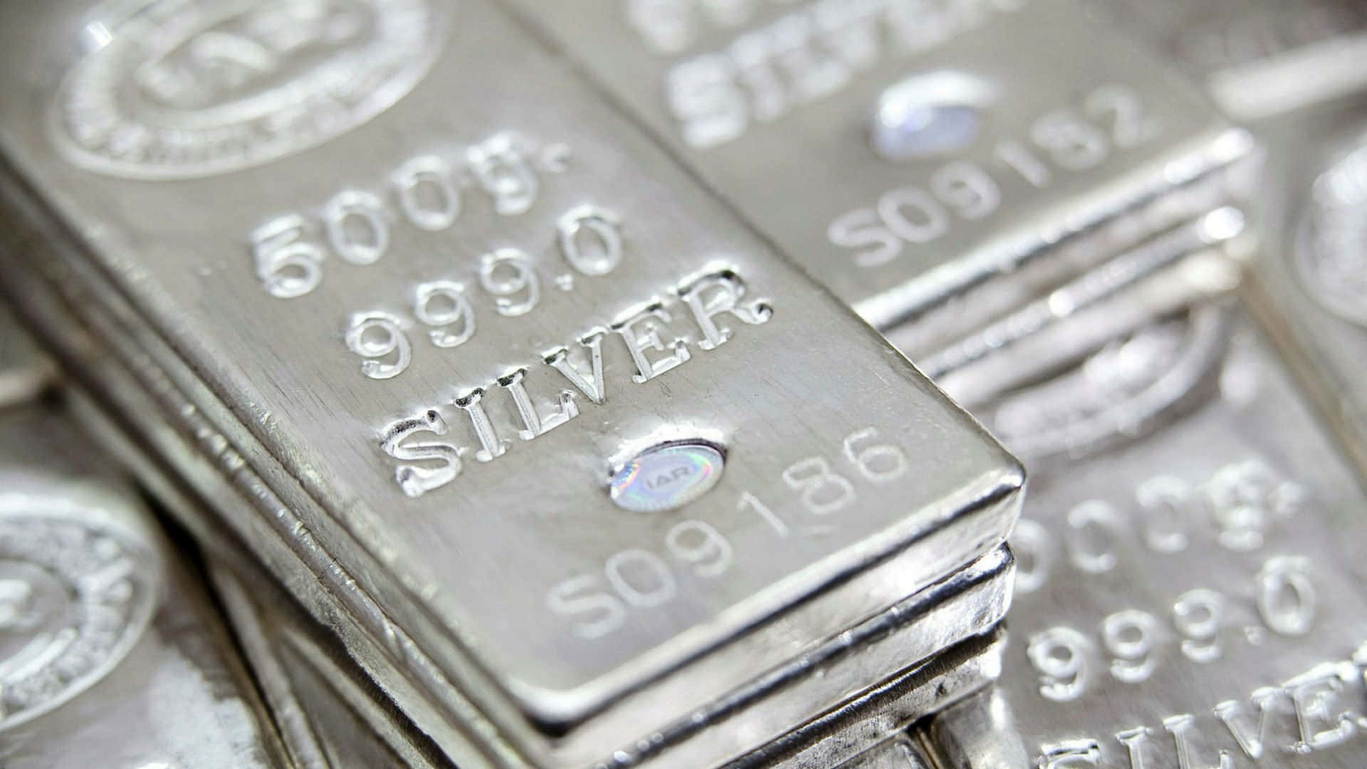 銀色 桌布 壁紙 — 閃亮銀條的特寫，上面印有「999.0 SILVER」和反光的序號。