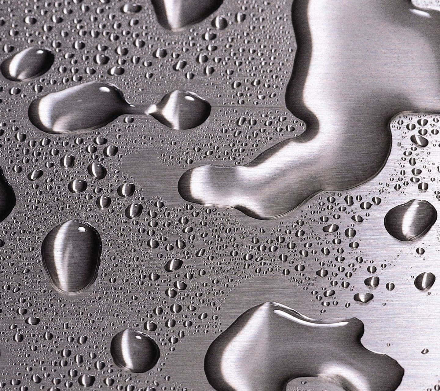 Liquid 桌布 壁紙 — 閃爍的水滴和水流在拉絲金屬表面上傾瀉而下，以水晶般的清晰度反射光線。