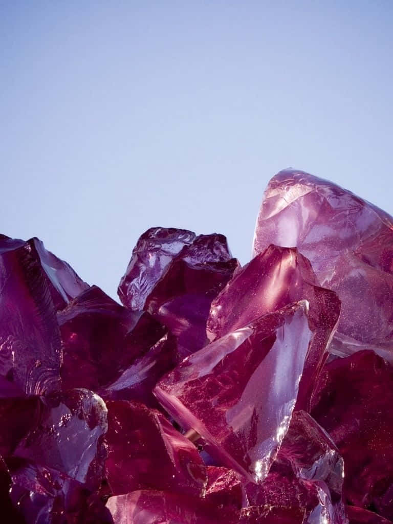 Amethyst 桌布 壁紙 — 閃爍的深紫色紫水晶簇在明亮的日光下映襯著柔和的藍天。