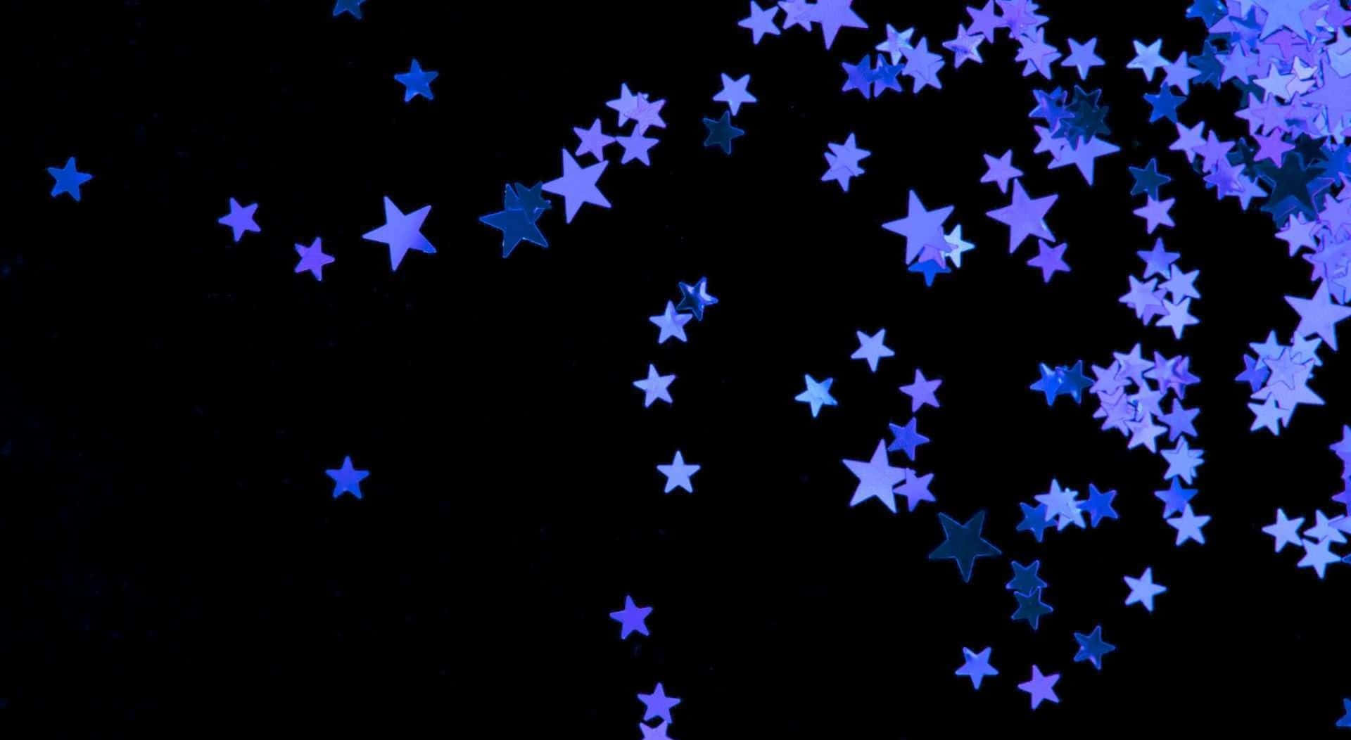 Aesthetic Star 桌布 壁紙 — 閃爍的藍色星形紙屑像墜落的天體閃粉一樣，沿對角線飄過深邃的黑色背景。