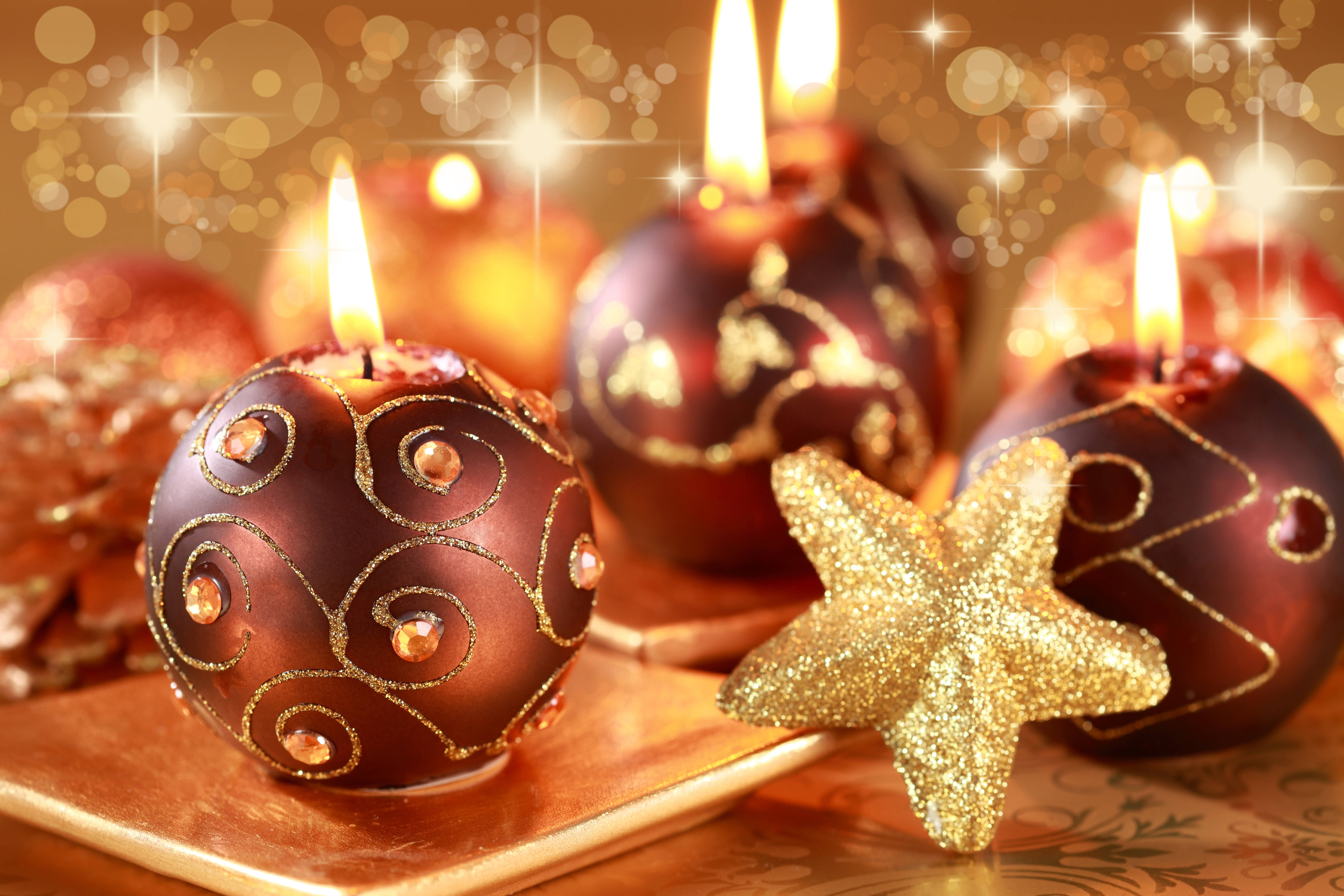 Christmas Balls 桌布 壁紙 — 閃爍的金色蠟燭，形狀像裝飾品，帶有閃閃發光的星星和溫暖的散景燈光，營造出節日的假日氛圍。