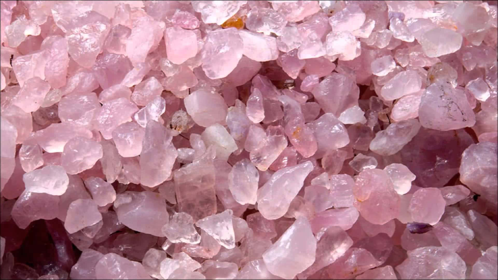 Pink Crystal Quartz 桌布 壁紙 — 閃爍粉紅玫瑰石英晶體的近距離特寫，具有半透明切面捕捉光線。