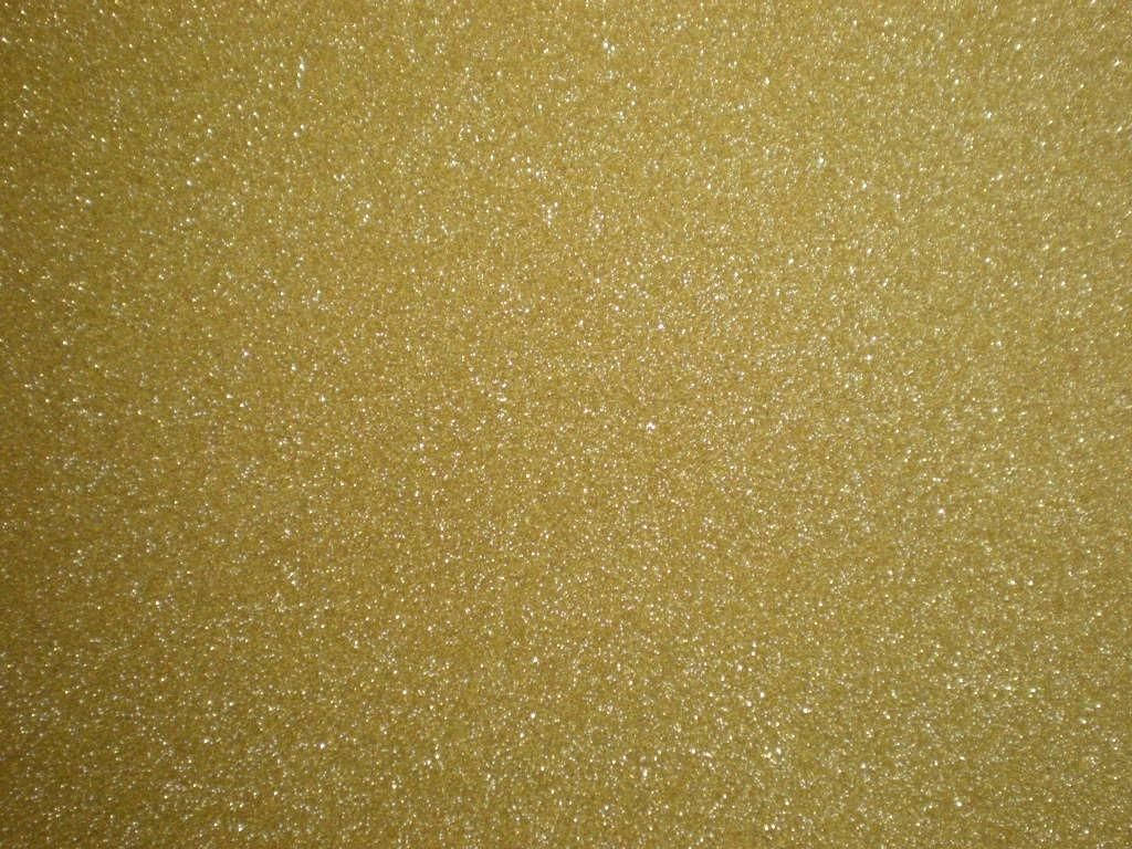 金色閃粉紋理近距離特寫，帶有閃亮顆粒。