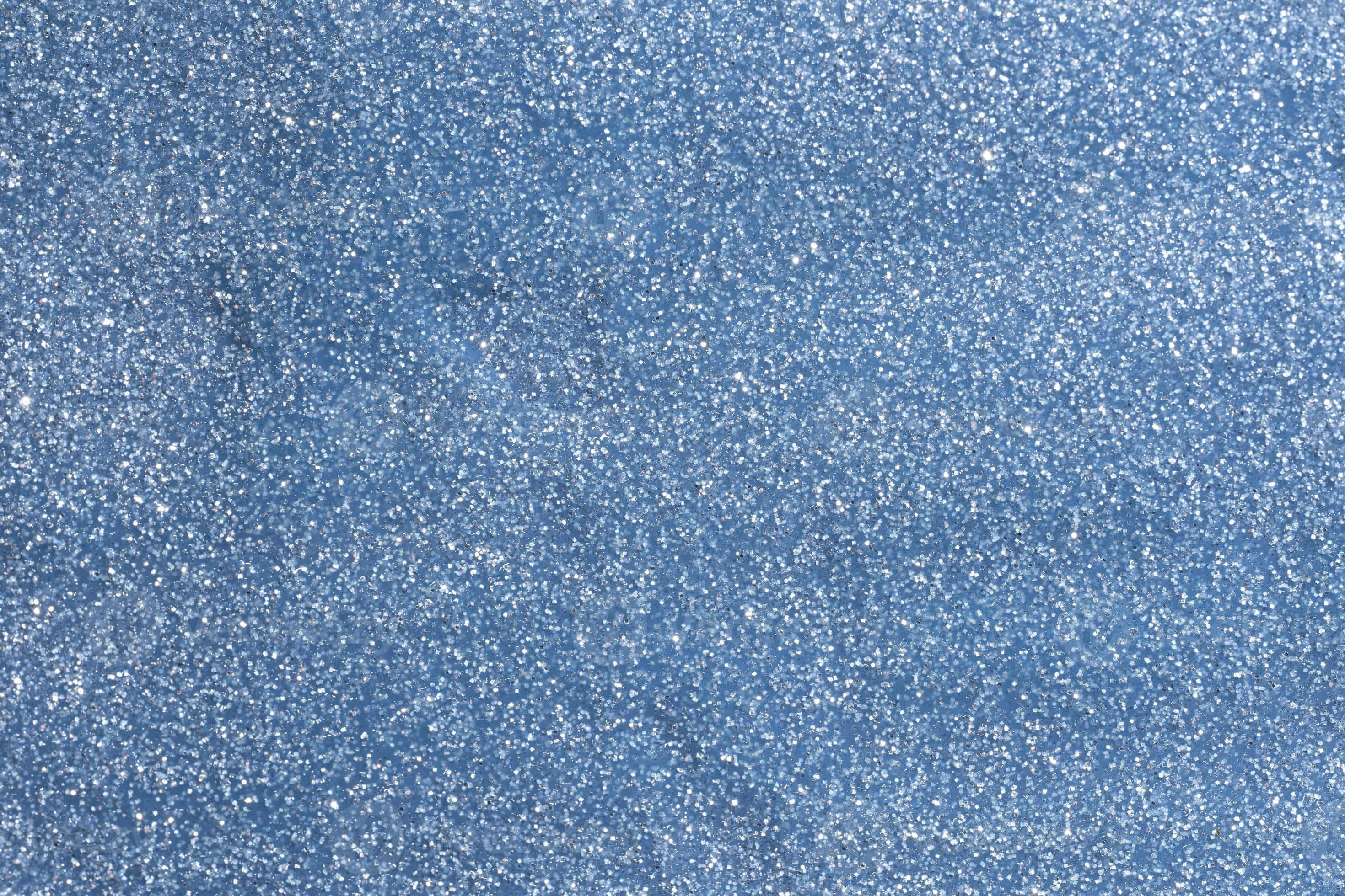 Periwinkle Blue 桌布 壁紙 — 閃爍藍色閃粉的特寫，帶有散落的銀色閃光，營造出有紋理且閃亮的表面。