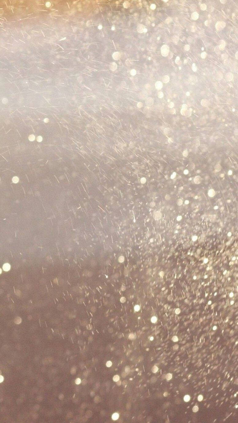 Gold Texture 桌布 壁紙 — 閃爍金色亮片微粒懸浮於柔和光線中的特寫，營造出閃耀的抽象紋理。