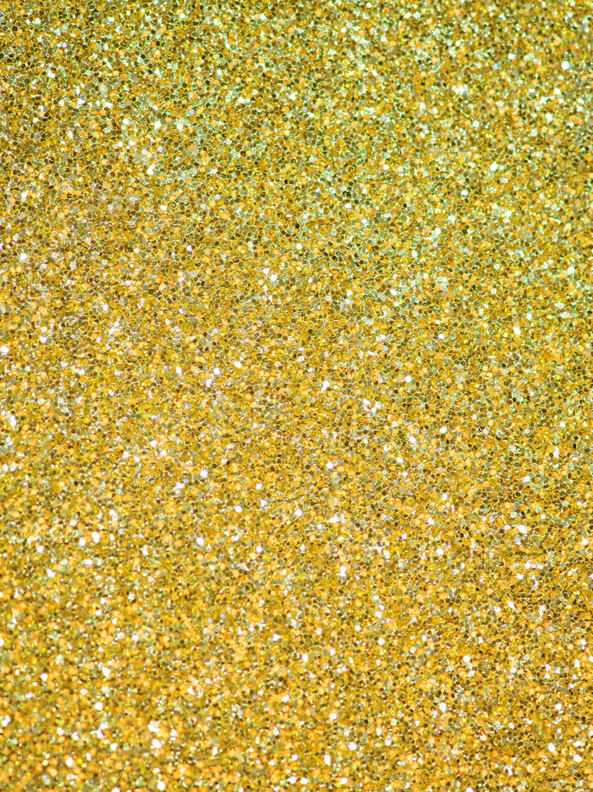 Yellow Glitter 桌布 壁紙 — 閃爍金色和白色閃粉的特寫，營造出閃閃發光的紋理表面。