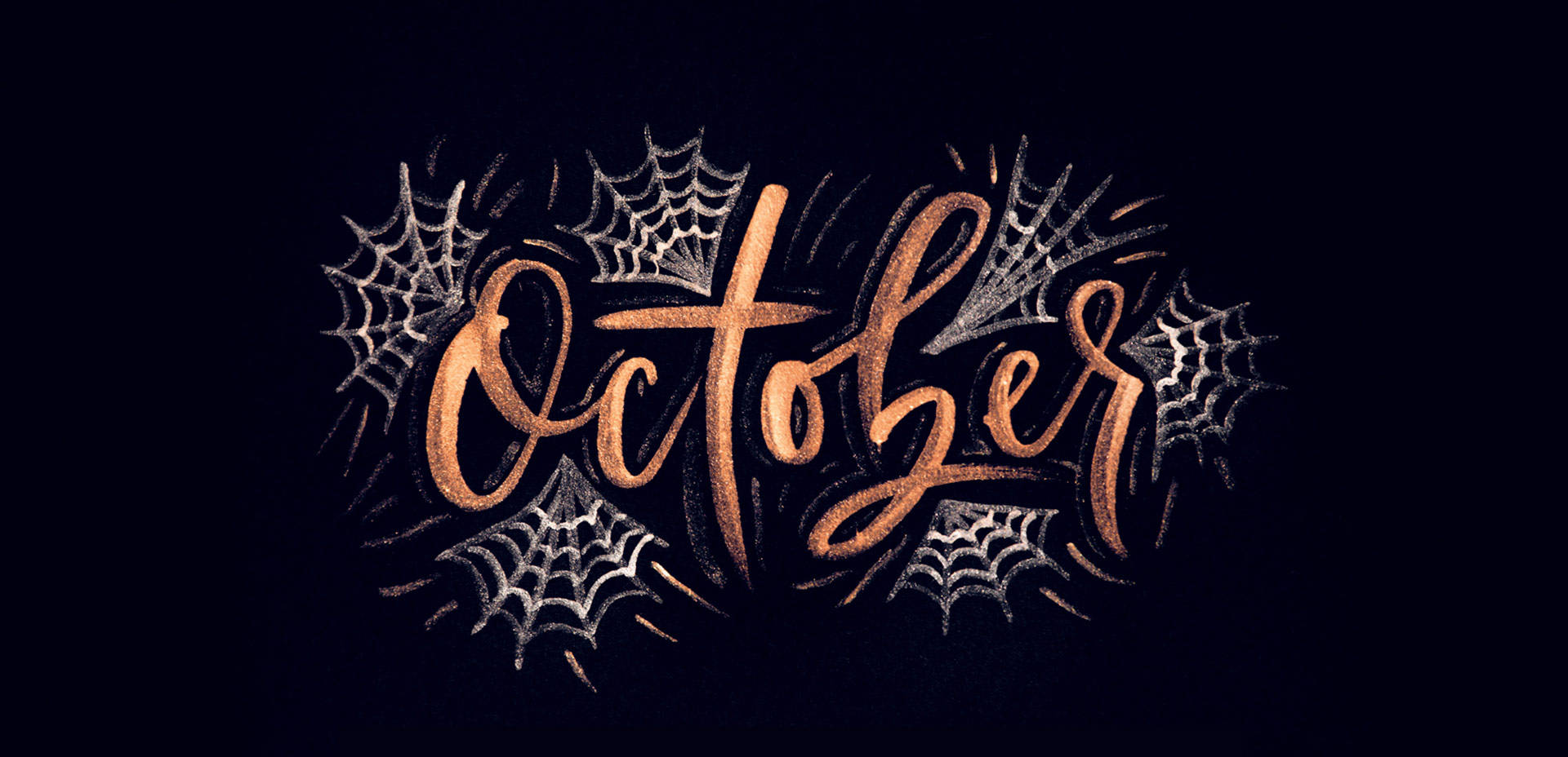 你好 桌布 壁紙 — 閃爍銅色字體的「October」一詞，在深色背景上被複雜的銀色蜘蛛網環繞。