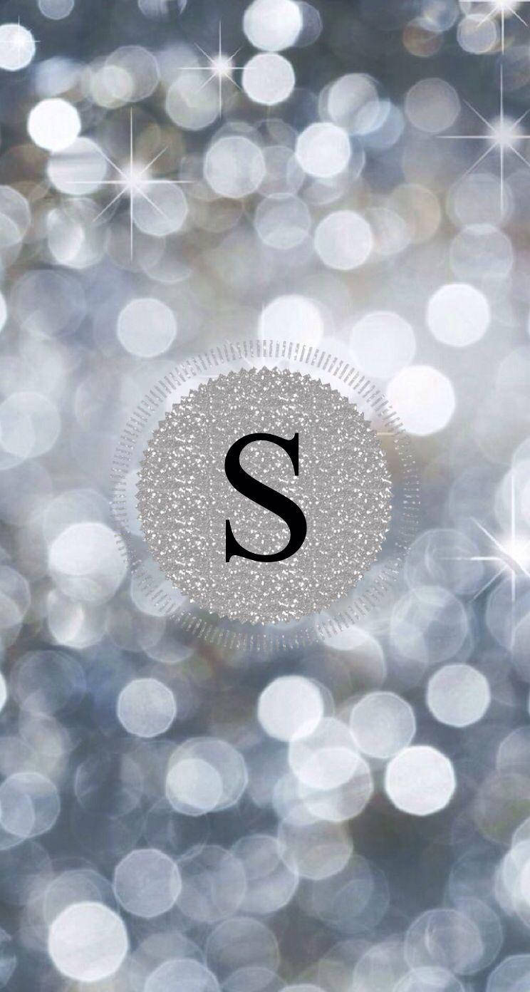 閃粉球內的S字母 壁紙 — 閃爍的銀色字母組合「S」在散景背景中閃閃發光，背景有閃爍的光圈和星芒。
