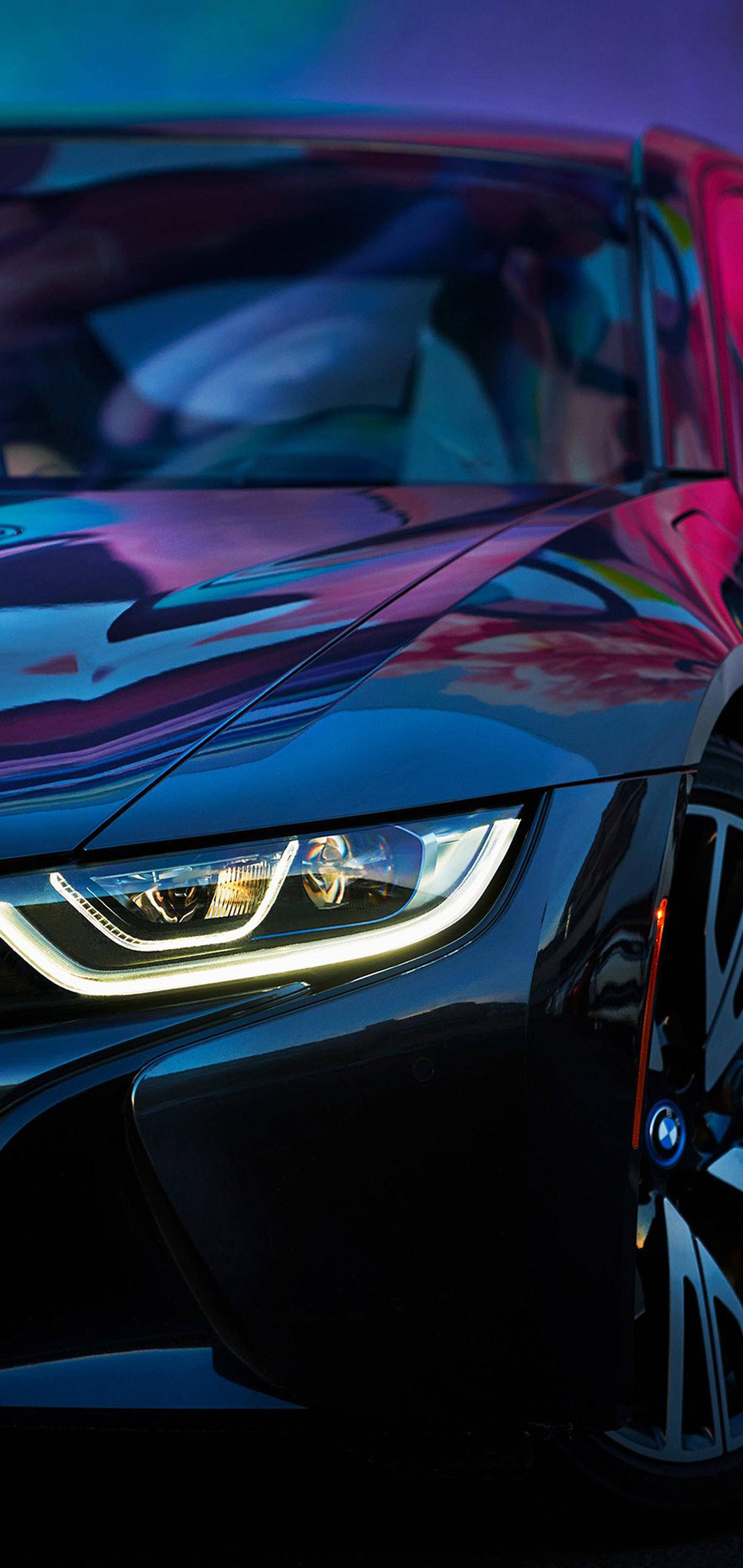 閃耀 BMW Galaxy S10 壁紙 — 一輛時尚的黑色跑車在霓虹燈下閃閃發光，充滿活力的紫色和粉紅色反射在其光澤表面上舞動。