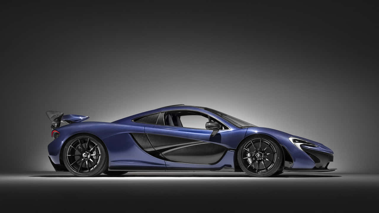 閃耀奪目的麥拉倫720S 壁紙 — 一輛時尚的藍色McLaren跑車在漸變灰色工作室背景和戲劇性燈光下側面滑行。