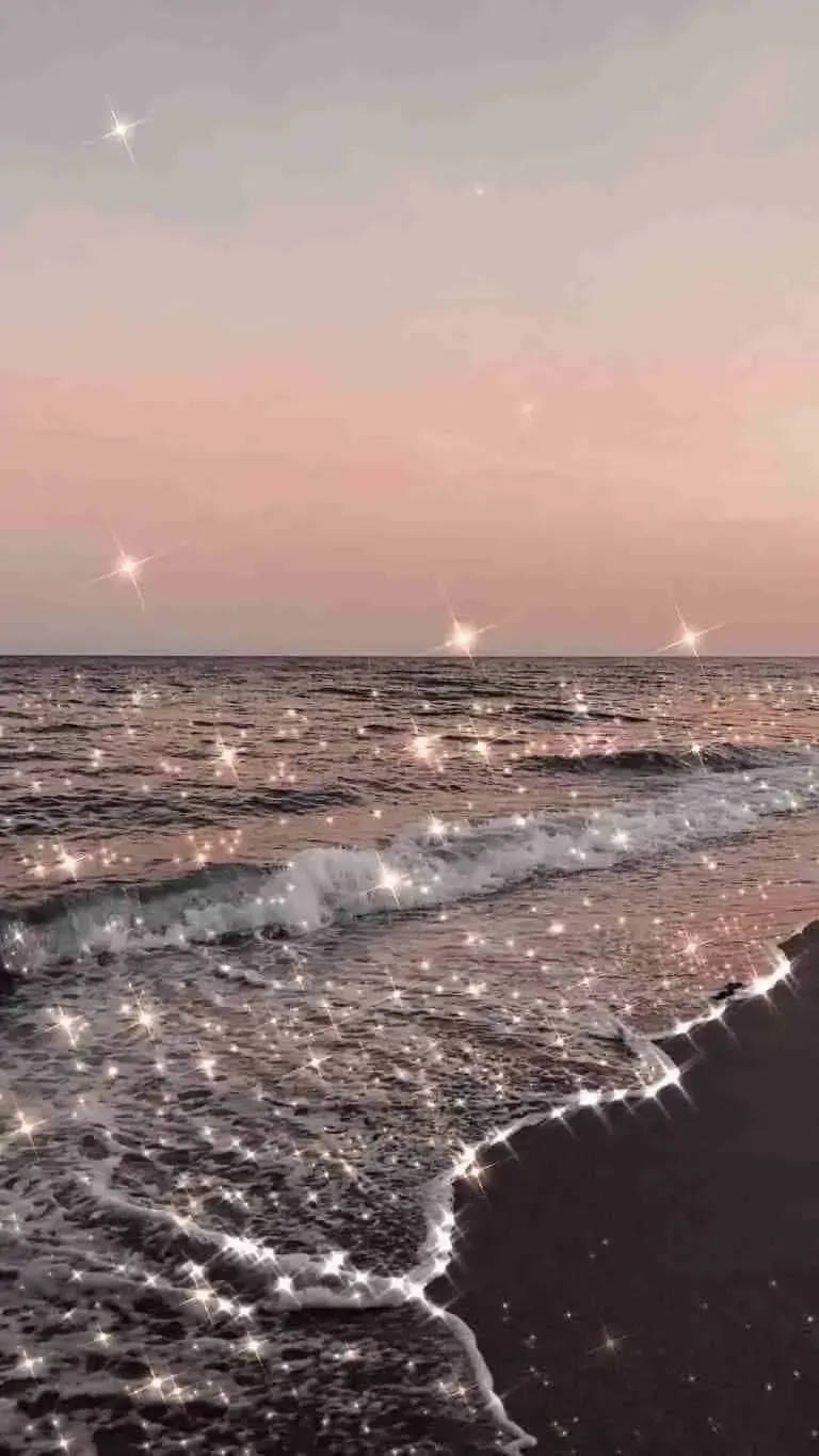海浪在粉紅色暮色天空下閃爍著星光。