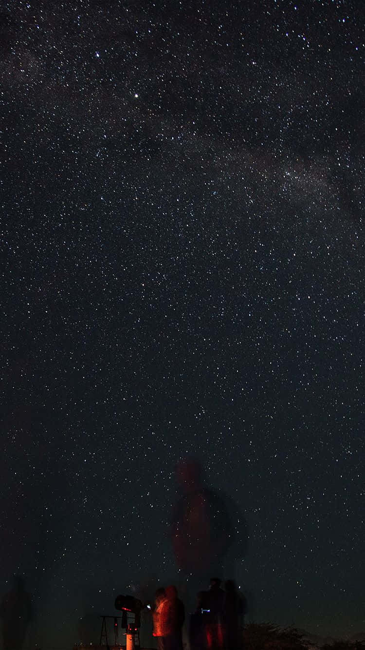 人們在星空下用望遠鏡觀察銀河系。