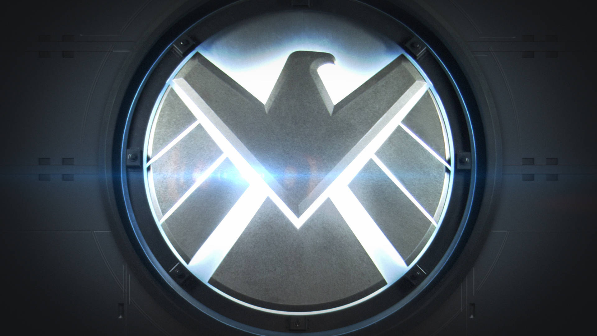 S.H.I.E.L.D.標誌在黑暗金屬房間內的圓形觀察窗中發光。 — 漫威 壁紙