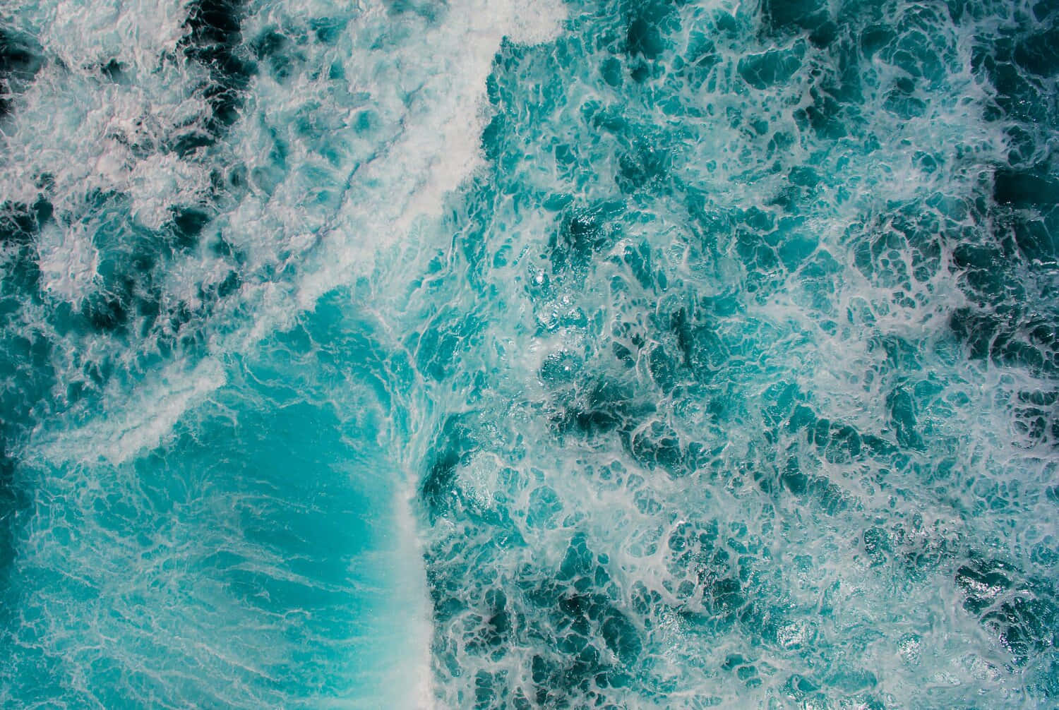 綠松石色的海浪與白色泡沫在空中視角中旋轉。