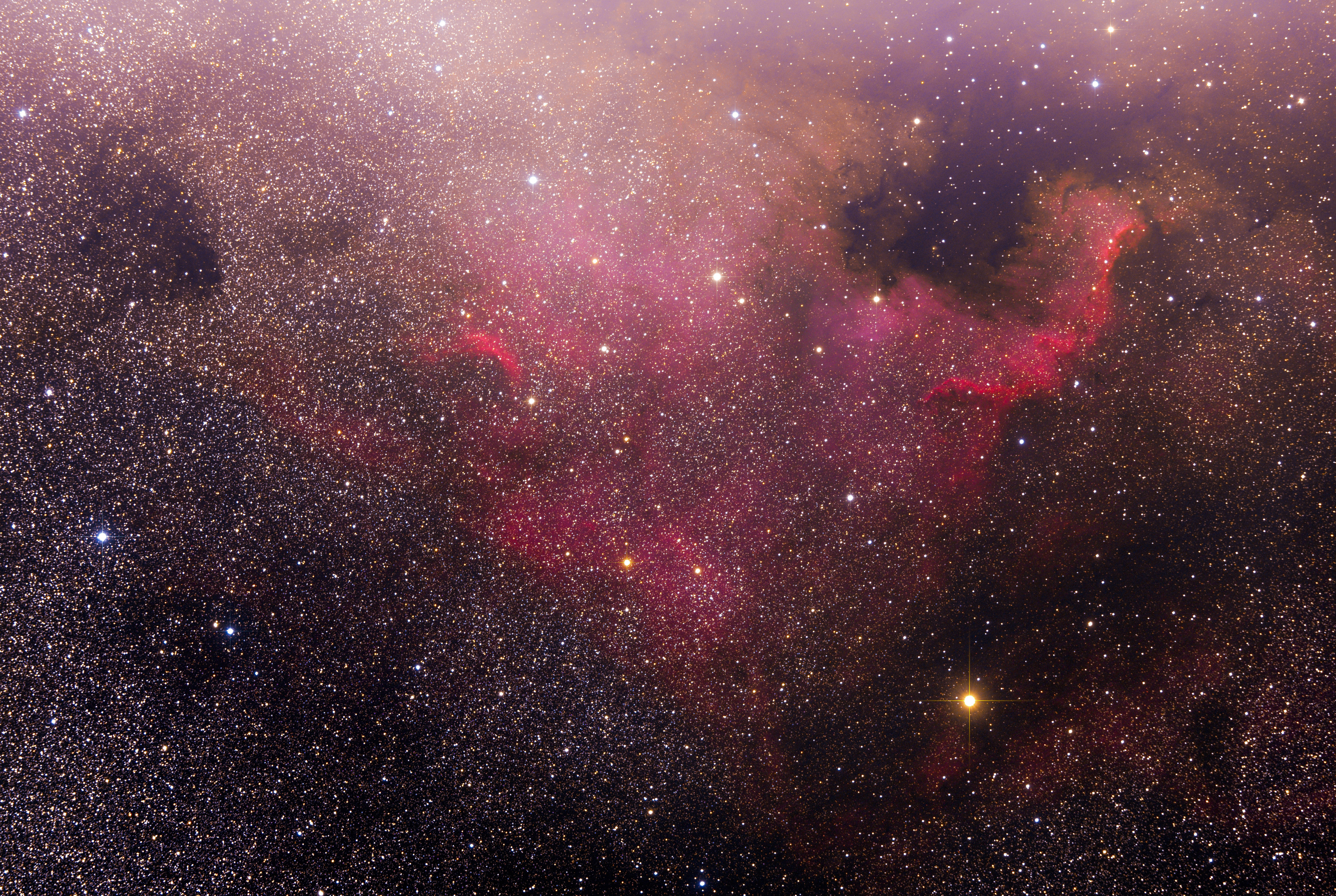 閃耀粉紅星系 壁紙 — 令人嘆為觀止的宇宙景觀，發光的粉紅色和金色星雲在無數閃爍的星星之間旋轉，映襯著深邃的黑色虛空。
