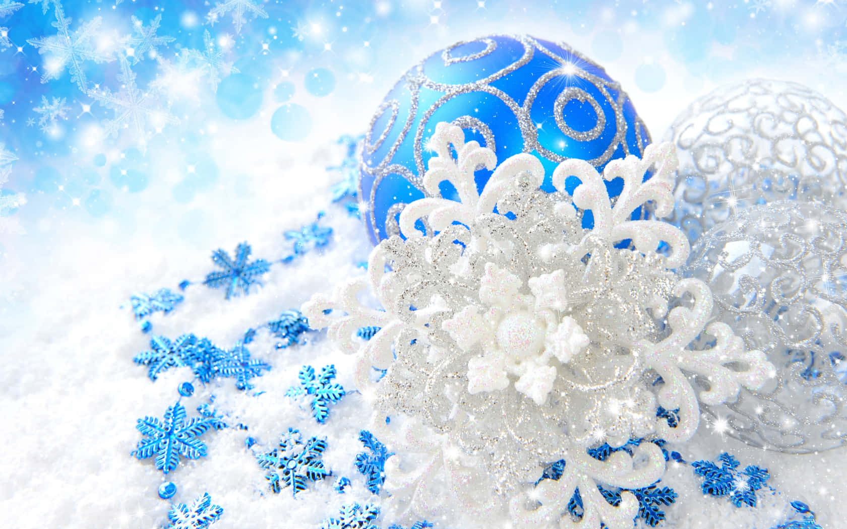 明亮的冬日天空下，雪地上有藍色和銀色的聖誕裝飾品和雪花。