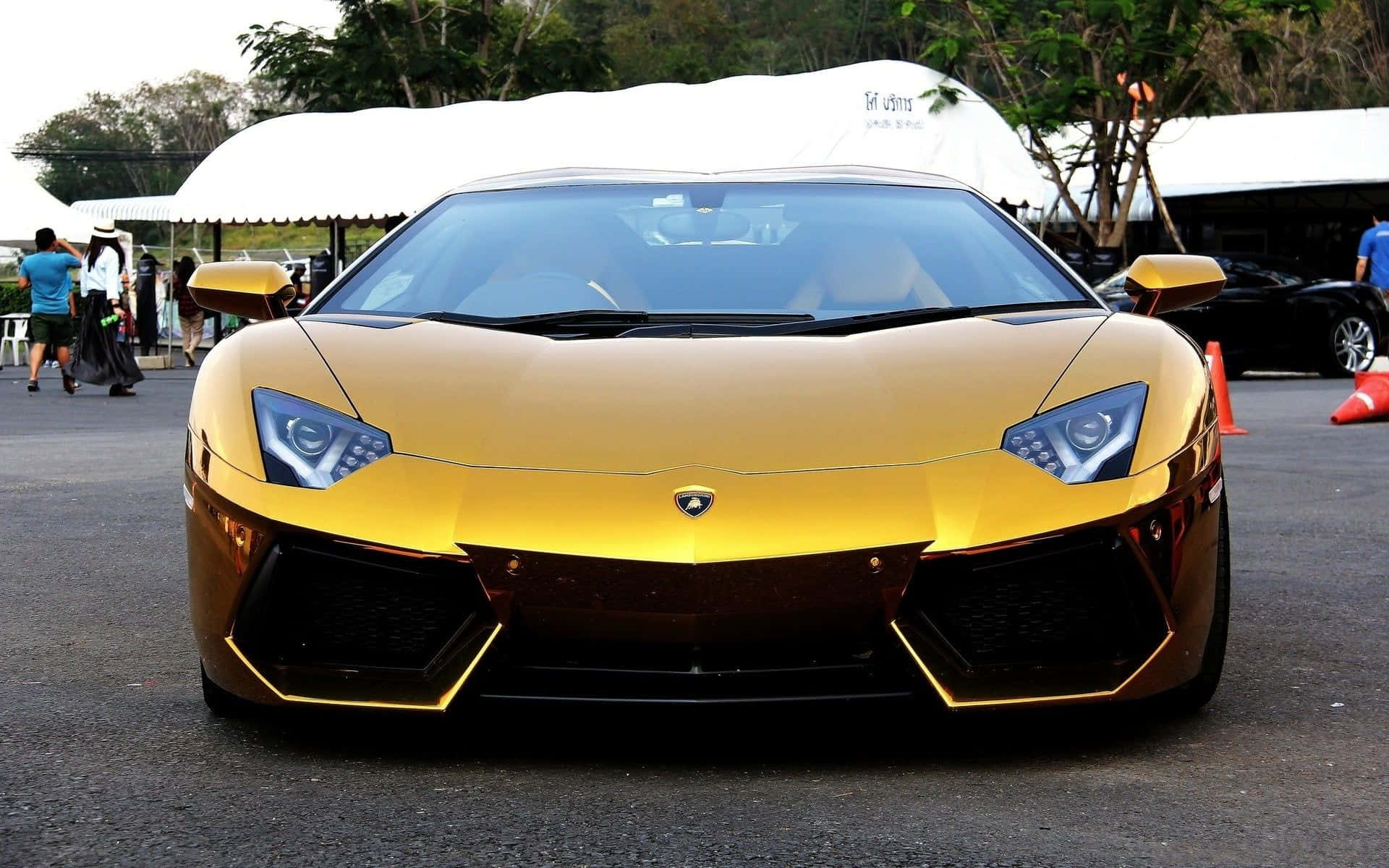 金色林寶堅尼Aventador在戶外車展活動中，附近有人群。