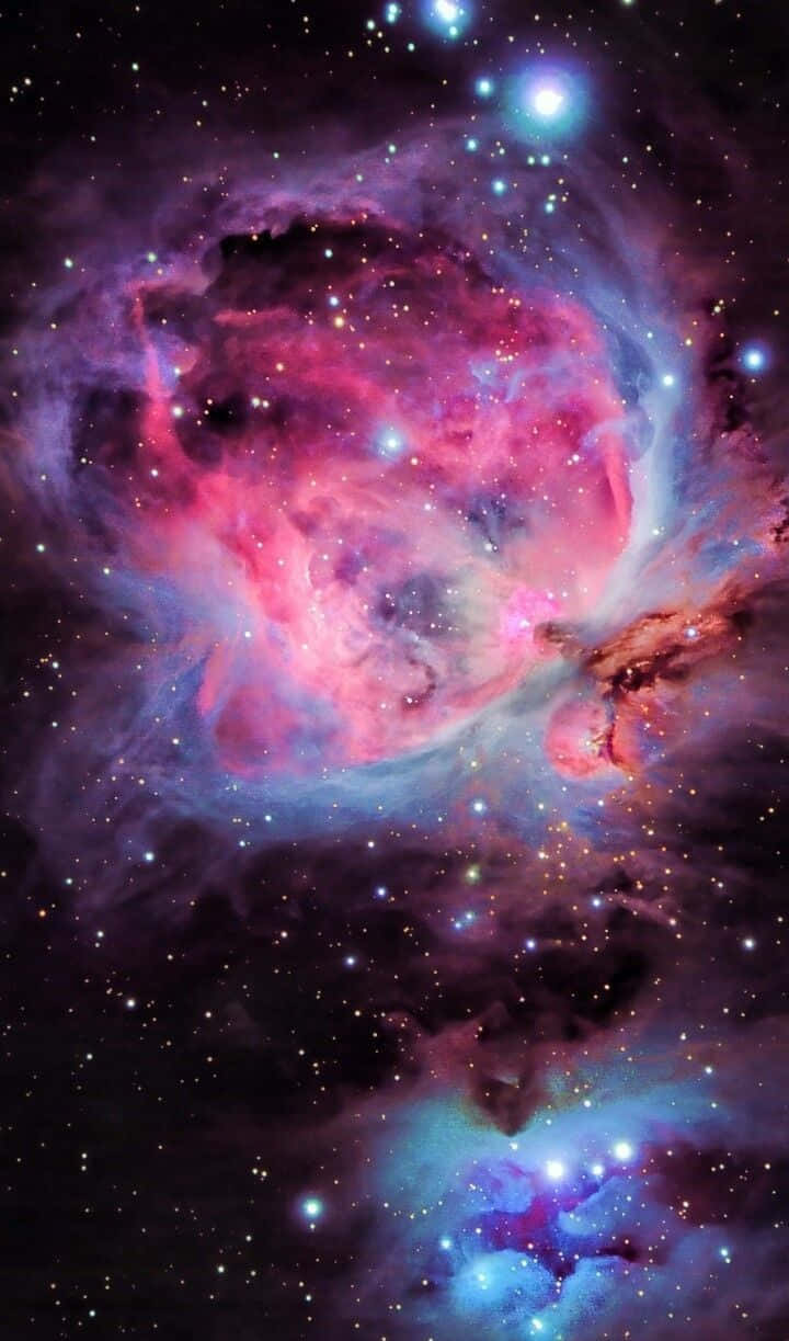 閃耀銀河爆發 壁紙 — 一個充滿活力的宇宙星雲，在黑暗虛空中由明亮恆星照亮的粉紅色、紫色和藍色氣體旋轉。