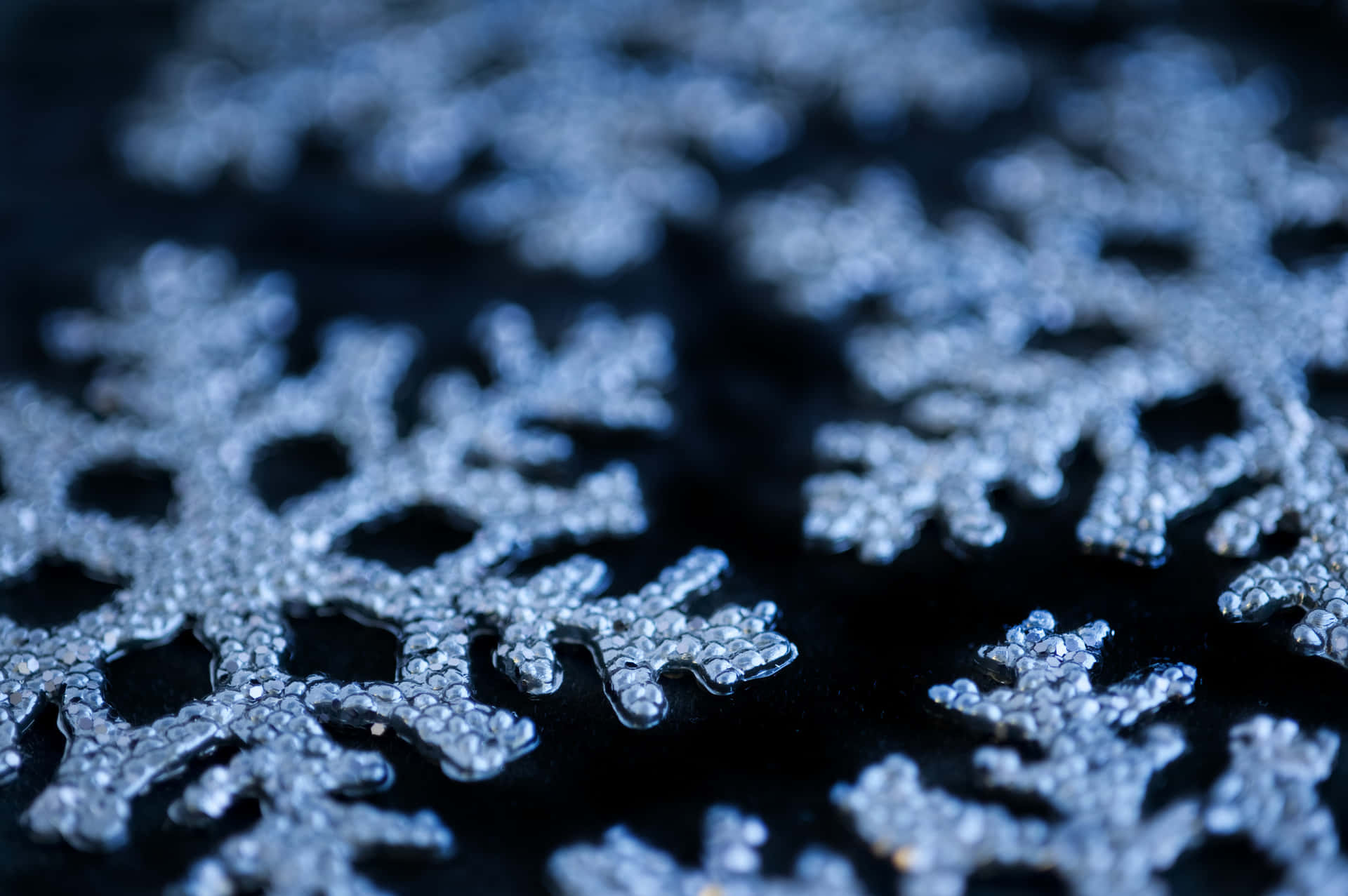 在深色表面上閃閃發光的銀色雪花裝飾