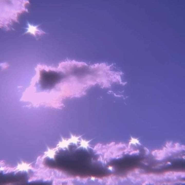 帶有閃爍星爆和柔和粉紅色雲層的紫色天空。