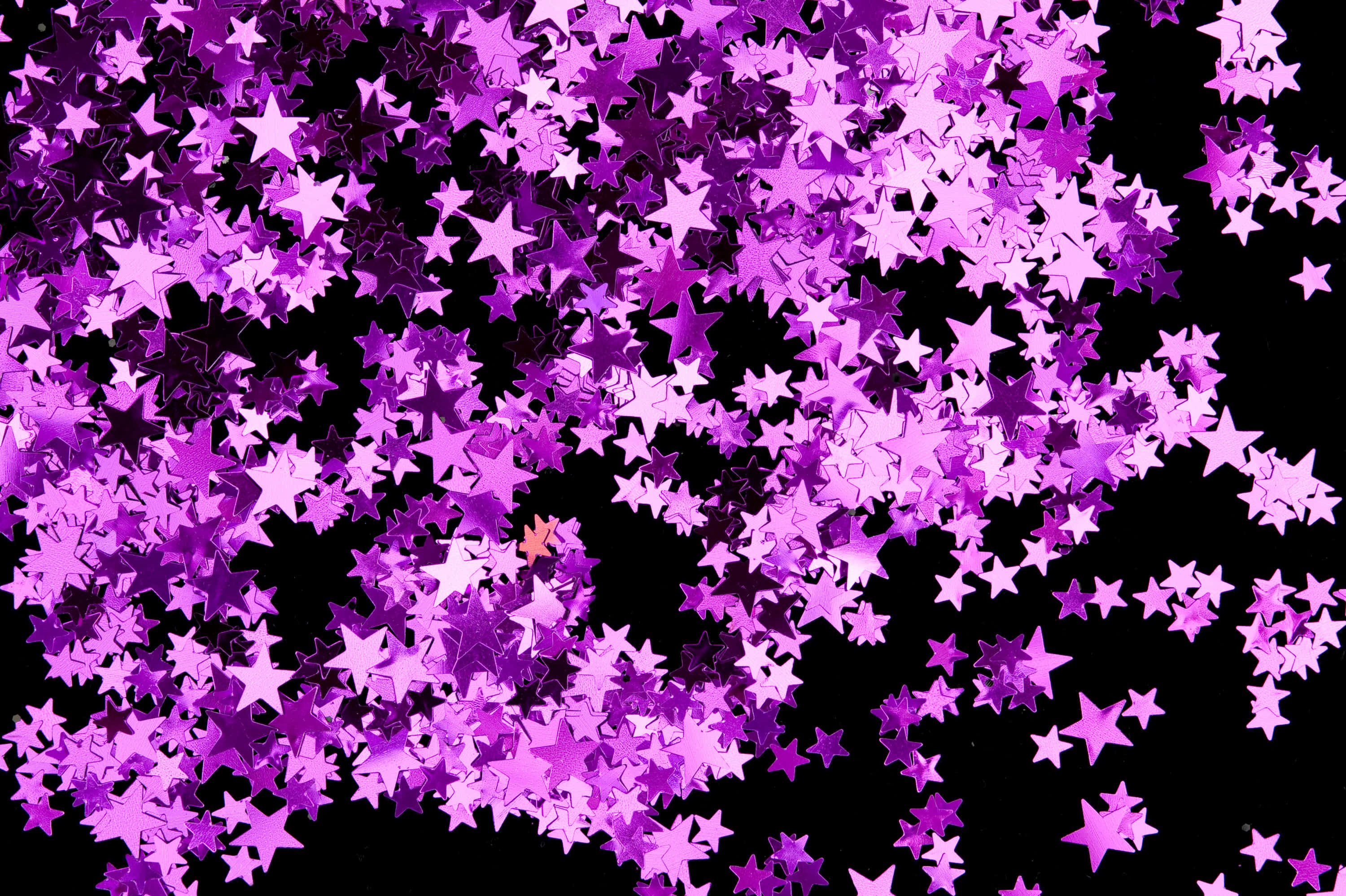 Pink Stars 桌布 壁紙 — 閃閃發光的紫色星形紙屑在純黑背景上如瀑布般爆發。