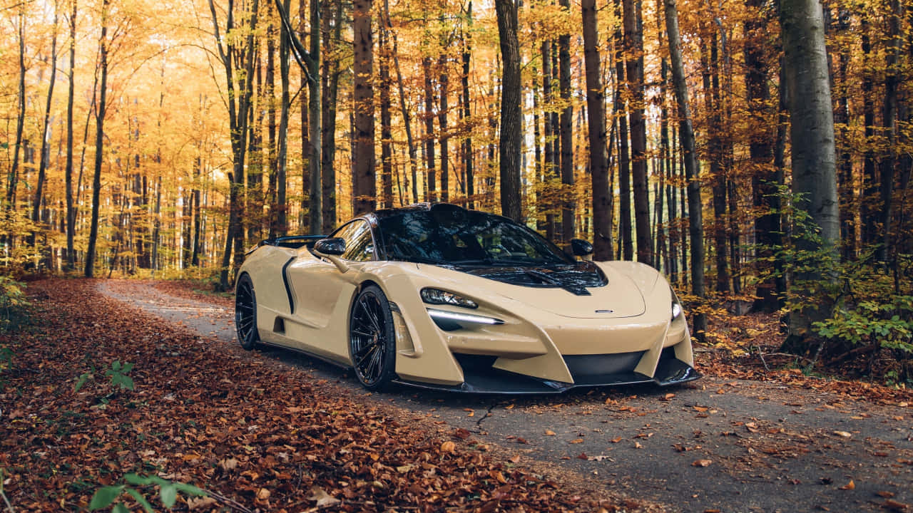 「閃電般的720P 麥拉倫720S」 壁紙 — 一輛奶油色McLaren跑車停在落葉滿地的森林道路上，上方是金黃色的秋樹。