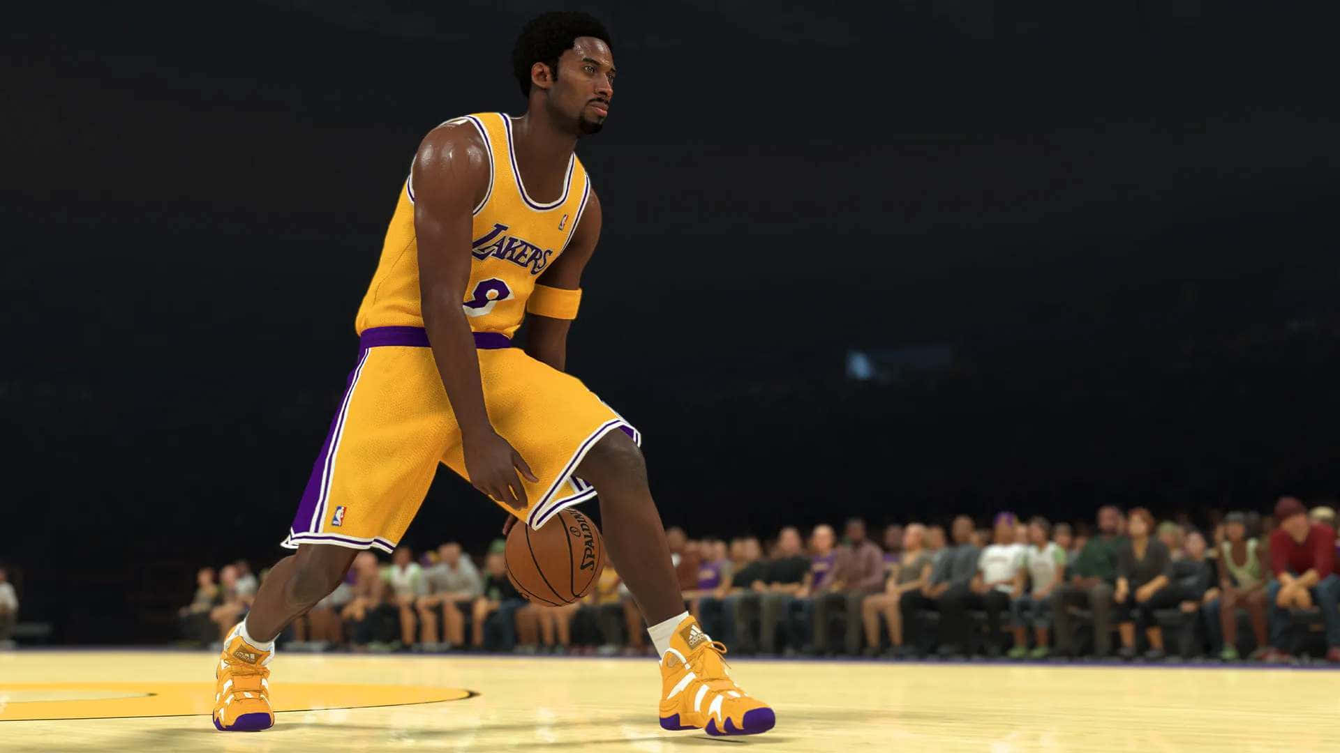 開啓 NBA 2K21 遊戲，展現你的運動實力！ 壁紙 — 一位身穿黃色湖人隊球衣的籃球運動員在燈光明亮的球場上運球，背景是模糊的人群。