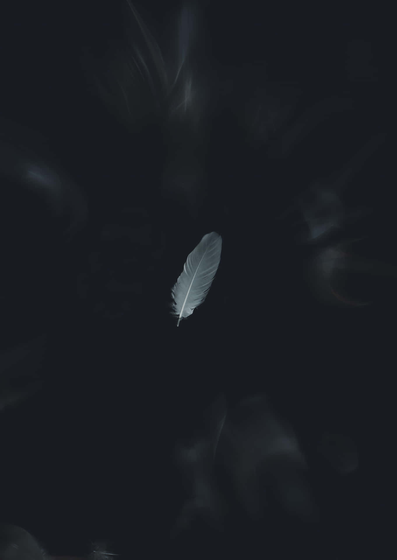 懸浮在深色煙霧中的發光白色羽毛