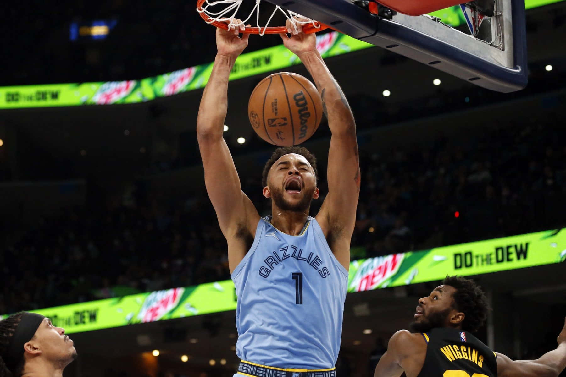 開心又搞笑的NBA籃球照片 壁紙 — 一名身穿淺藍色灰熊隊球衣的籃球運動員在明亮的場館燈光下，於比賽中專注地灌籃。